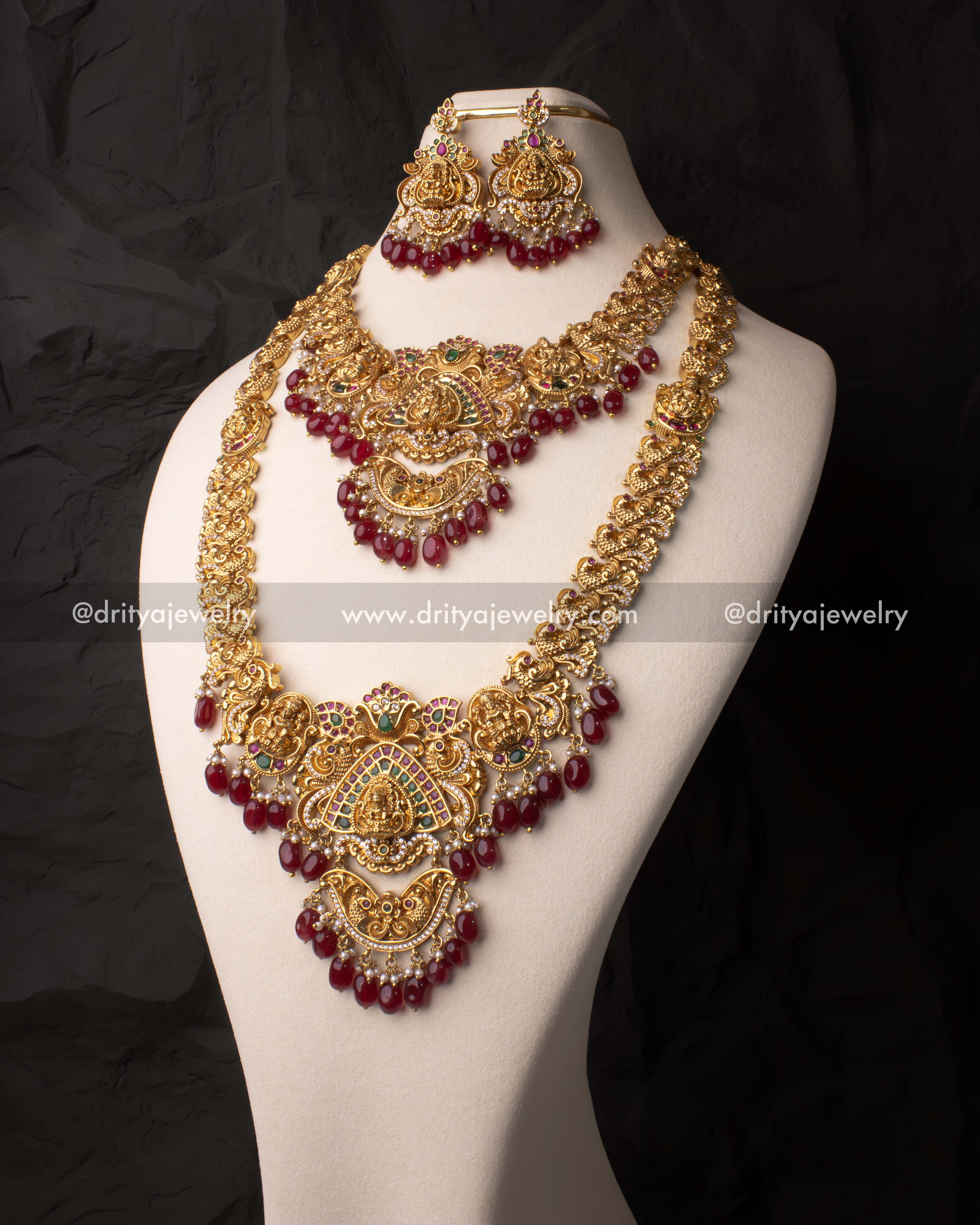 Front view of Lakshmi Devi motif long haram bridal necklace set adorned with gemstones and pearls by Dritya Jewelry.