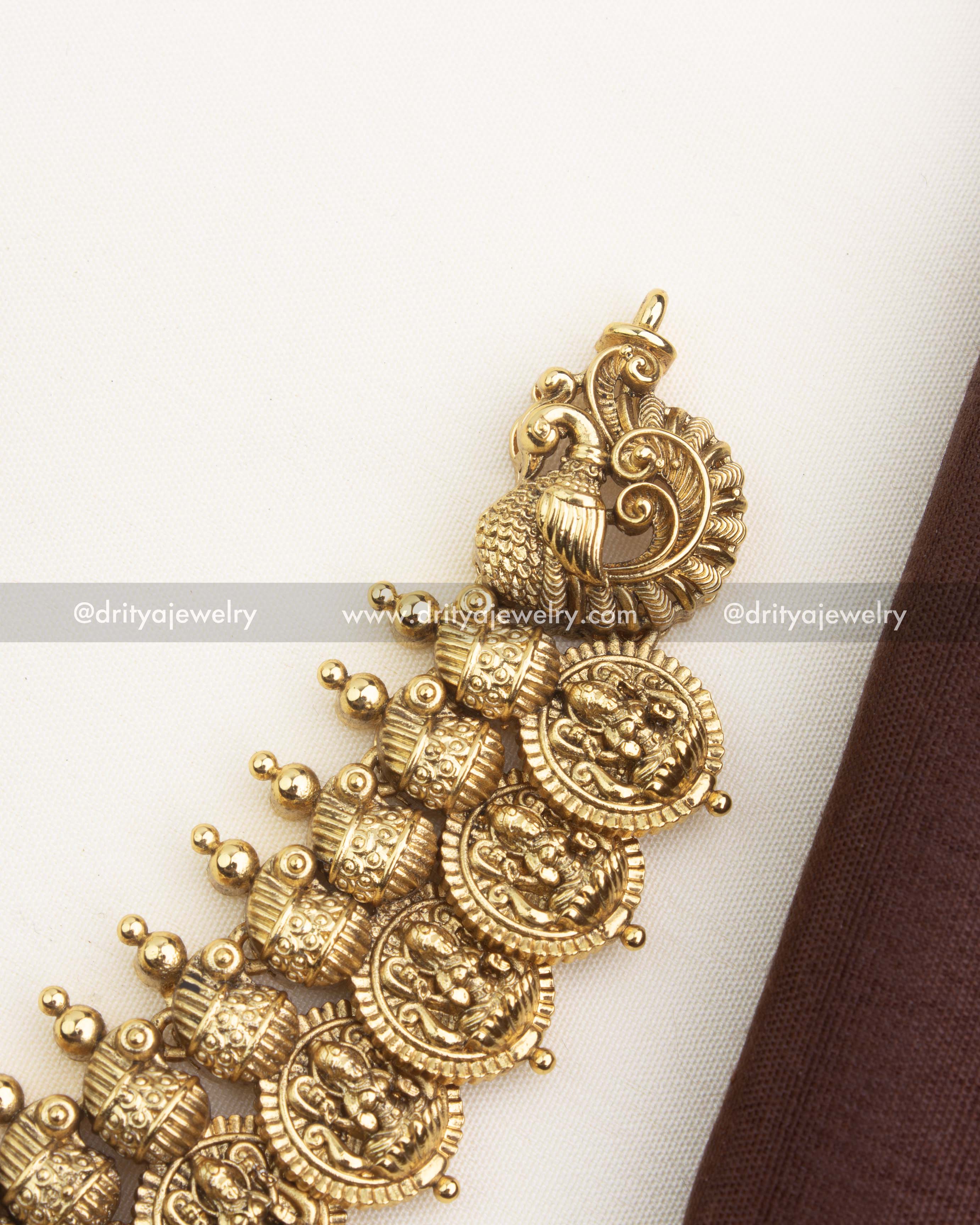 Close-up of antique gold Lakshmi coin motifs with textured dome elements and handcrafted temple detailing.