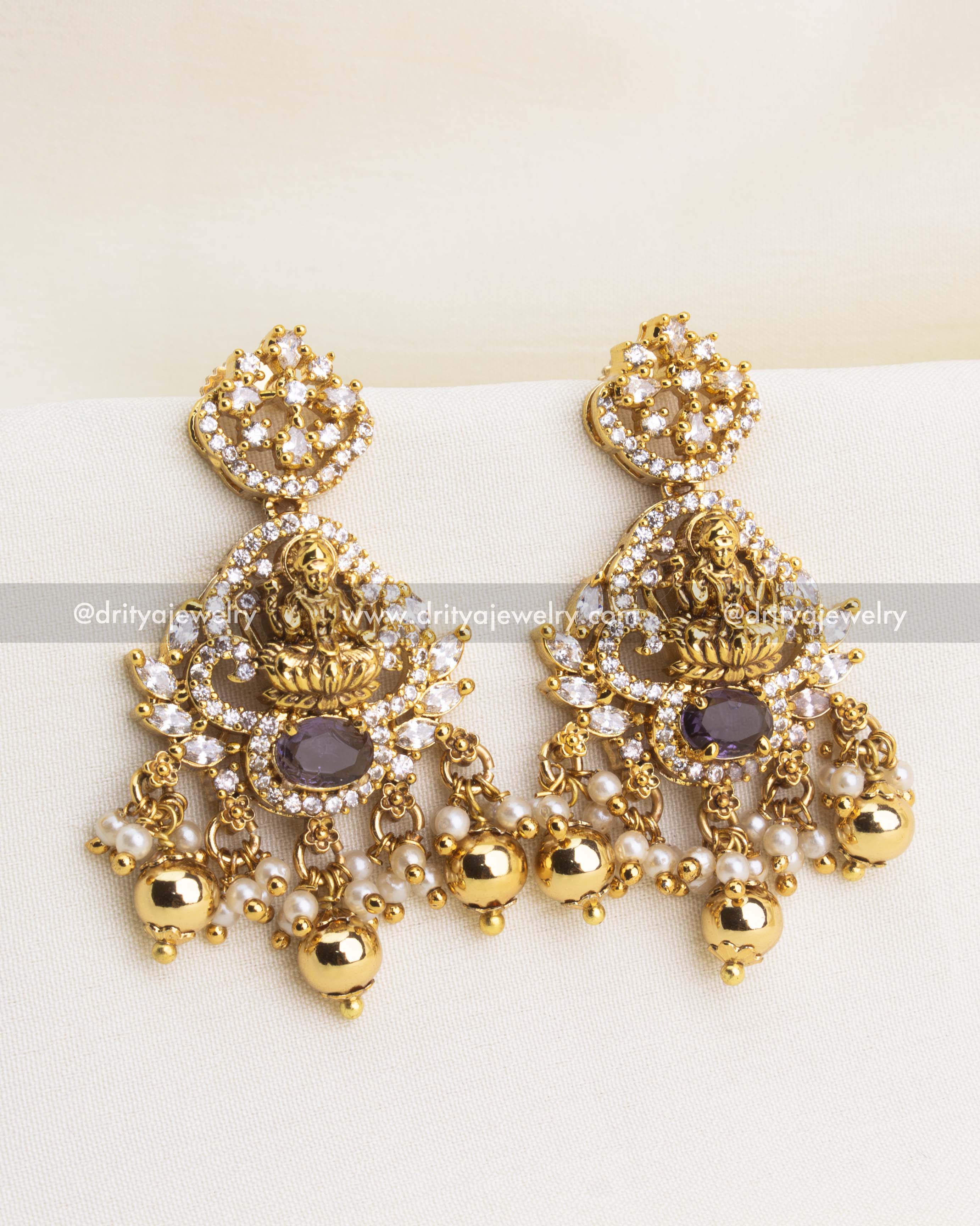 Temple-inspired earrings with Lakshmi motif, CZ stones, pearls, and gold bead drops.