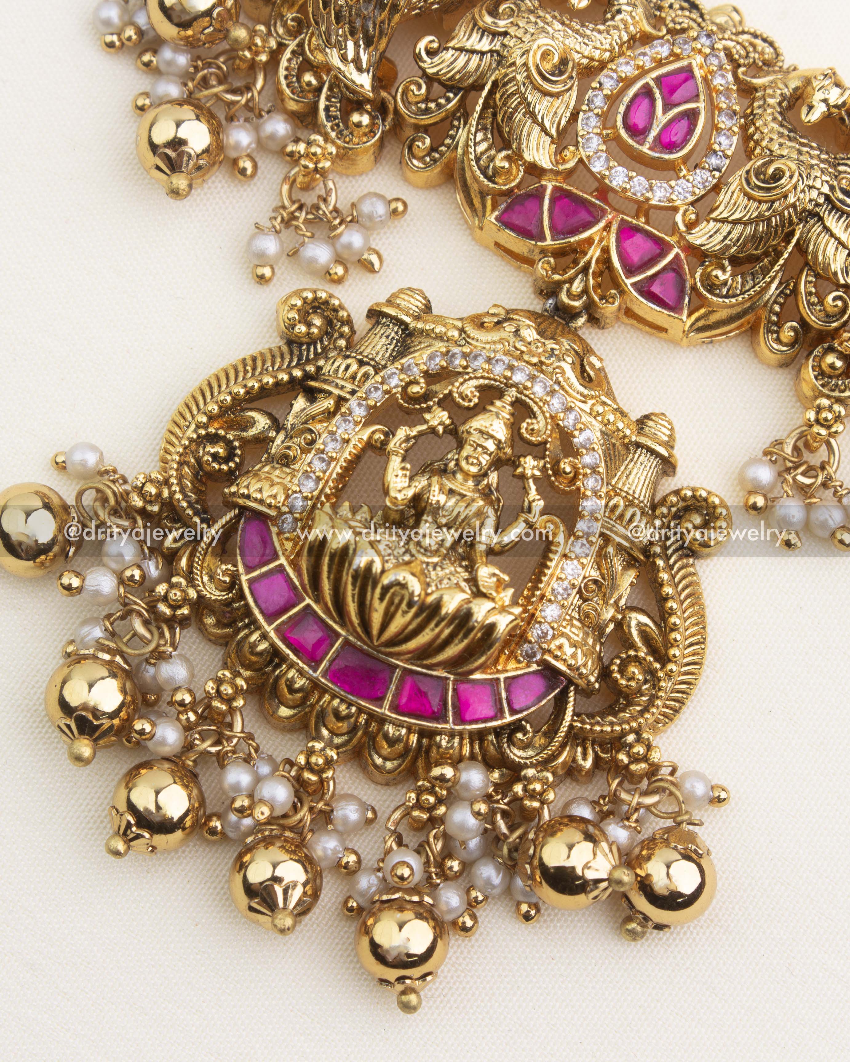 Temple Lakshmi pendant featuring ruby kemp stones, pearl clusters, and gold ghungroo drops.