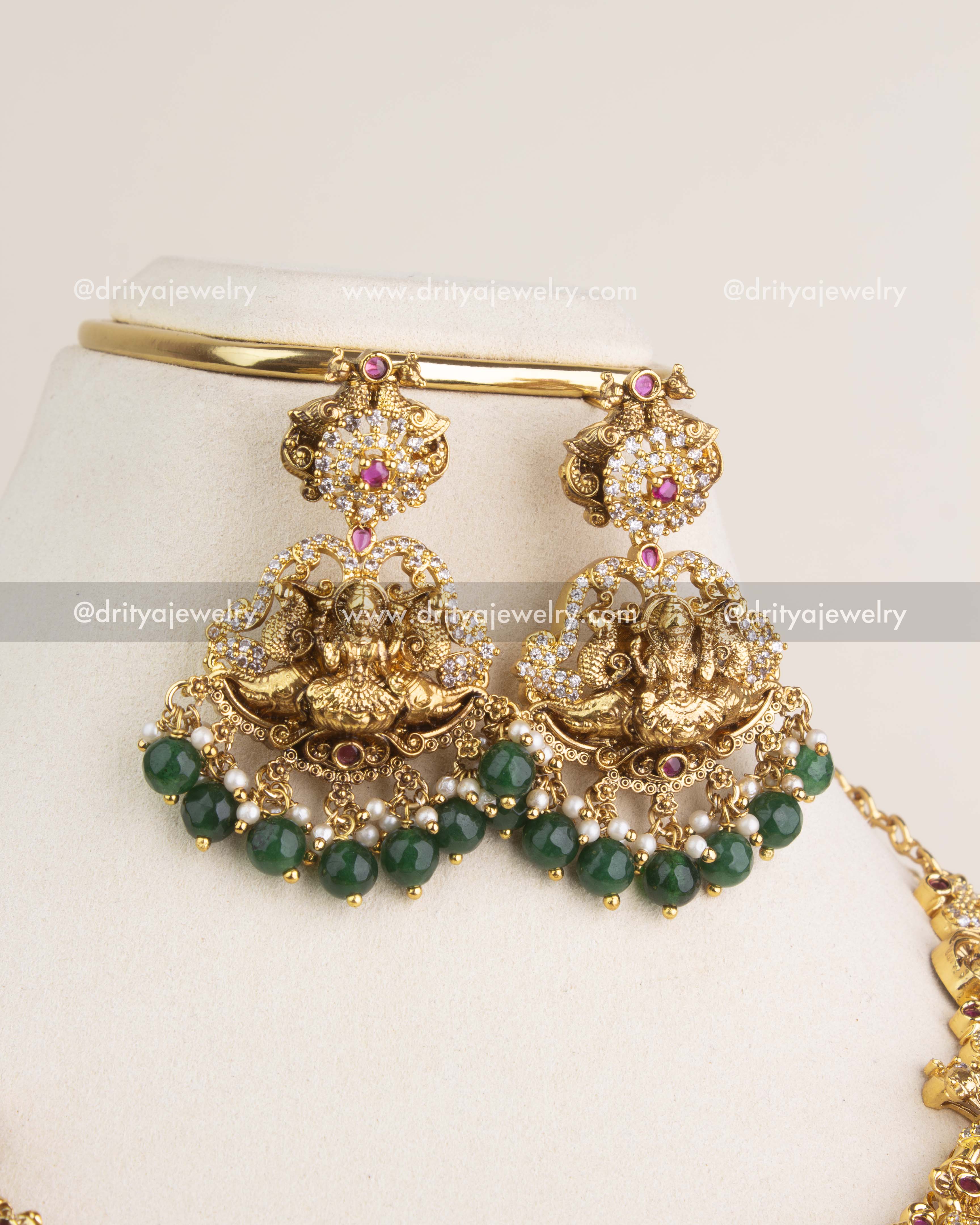 Nakshi temple dangler earrings with Lakshmi design, ruby kemp detailing, and green bead hangings.