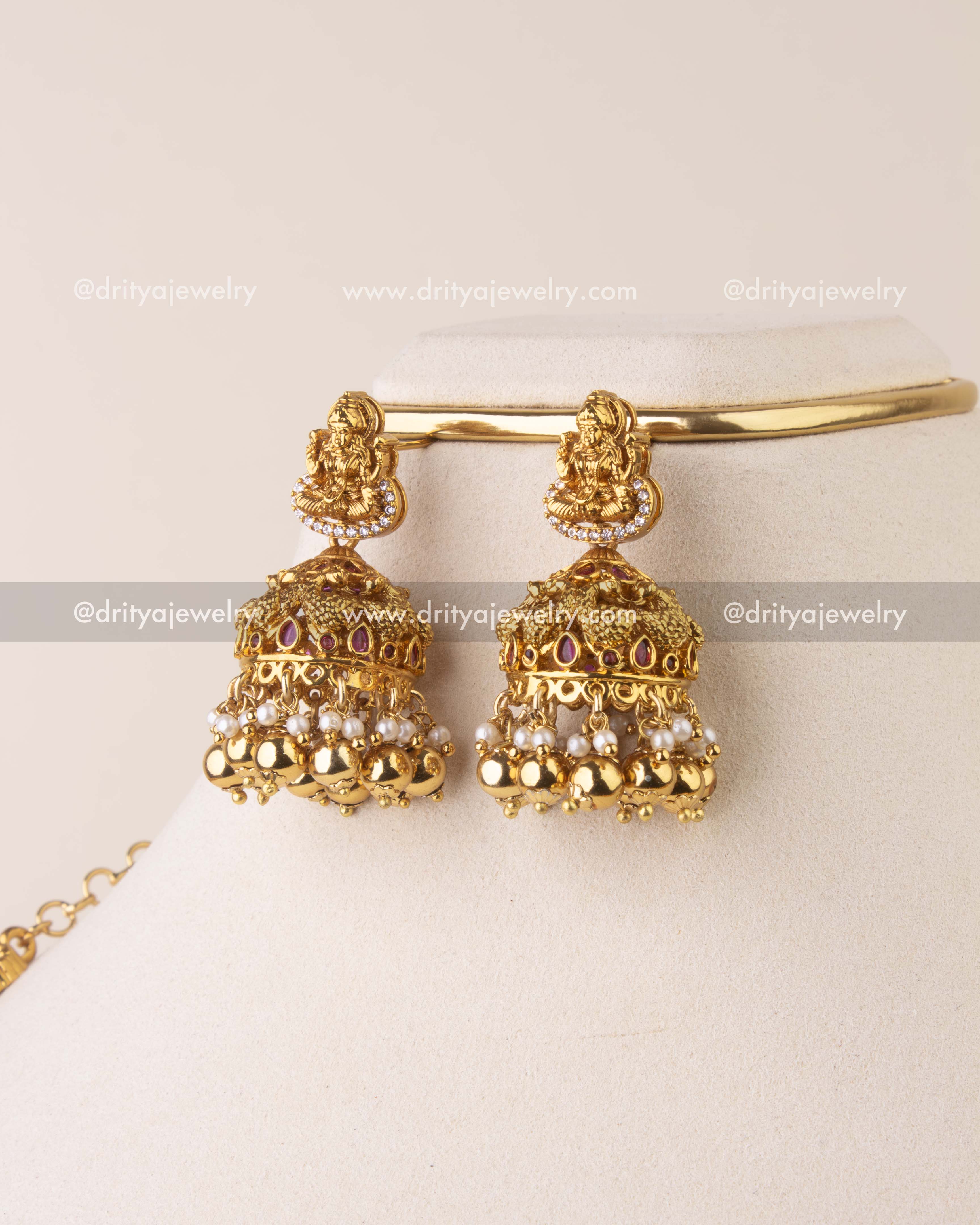 Traditional antique gold jhumka earrings with Lakshmi motif, Kemp accents, pearls, and golden bead drops.
