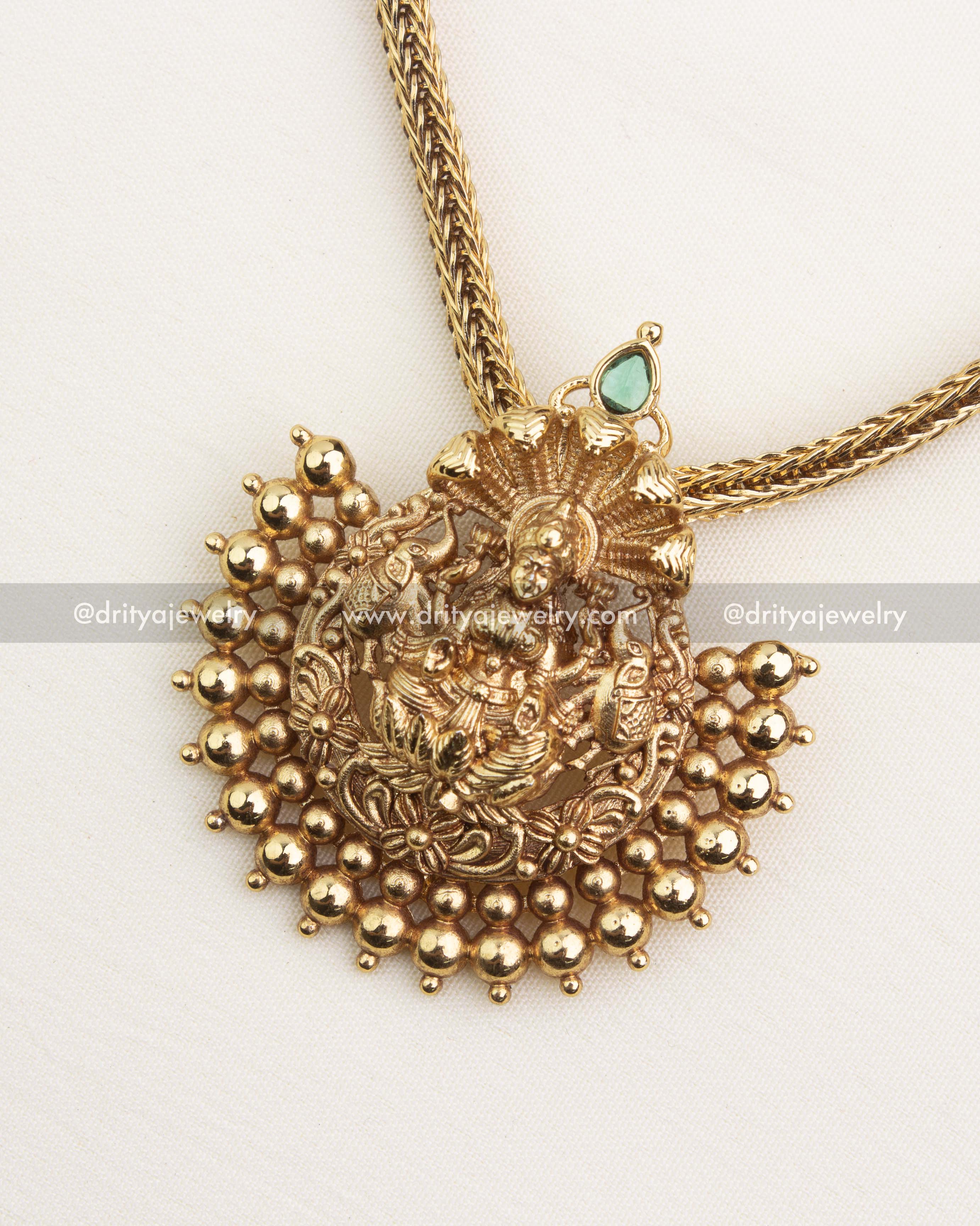 Temple-style Lakshmi stud earrings with green stone detailing and antique finish.