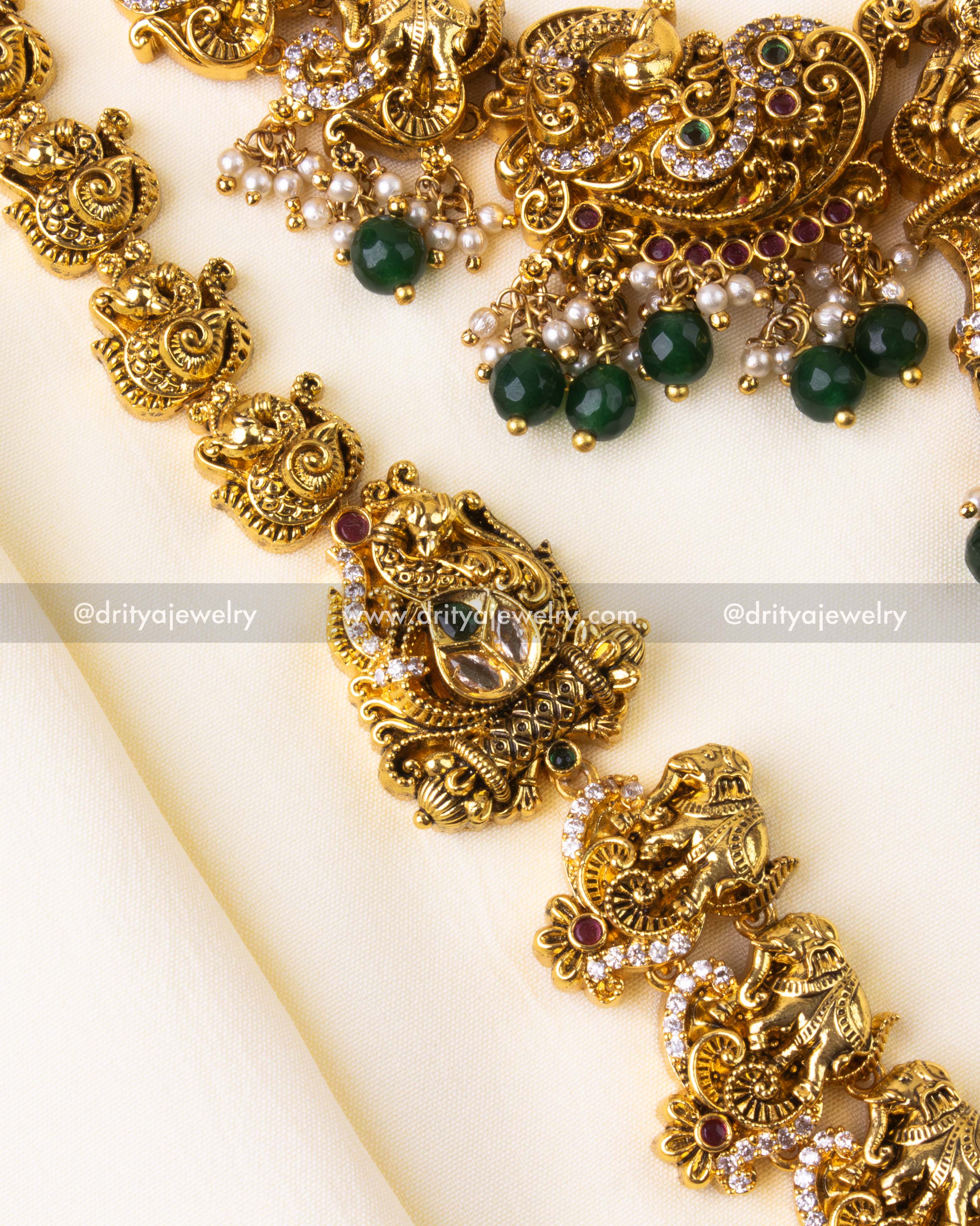 Close-up of long bridal necklace with alternating elephant and peacock temple motifs.