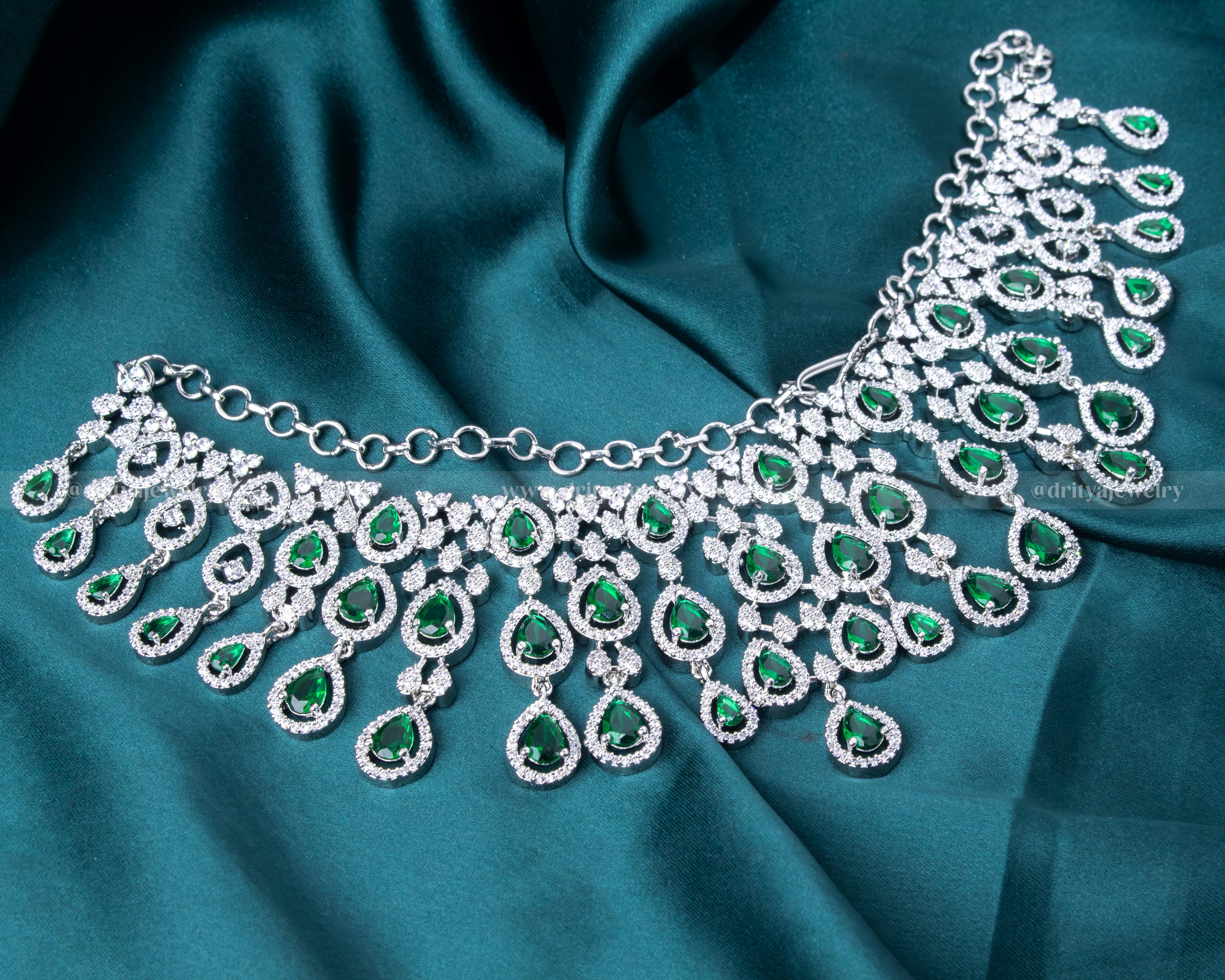 Elegant rhodium-plated necklace set with emerald and CZ stones, perfect for special occasions and formal events.