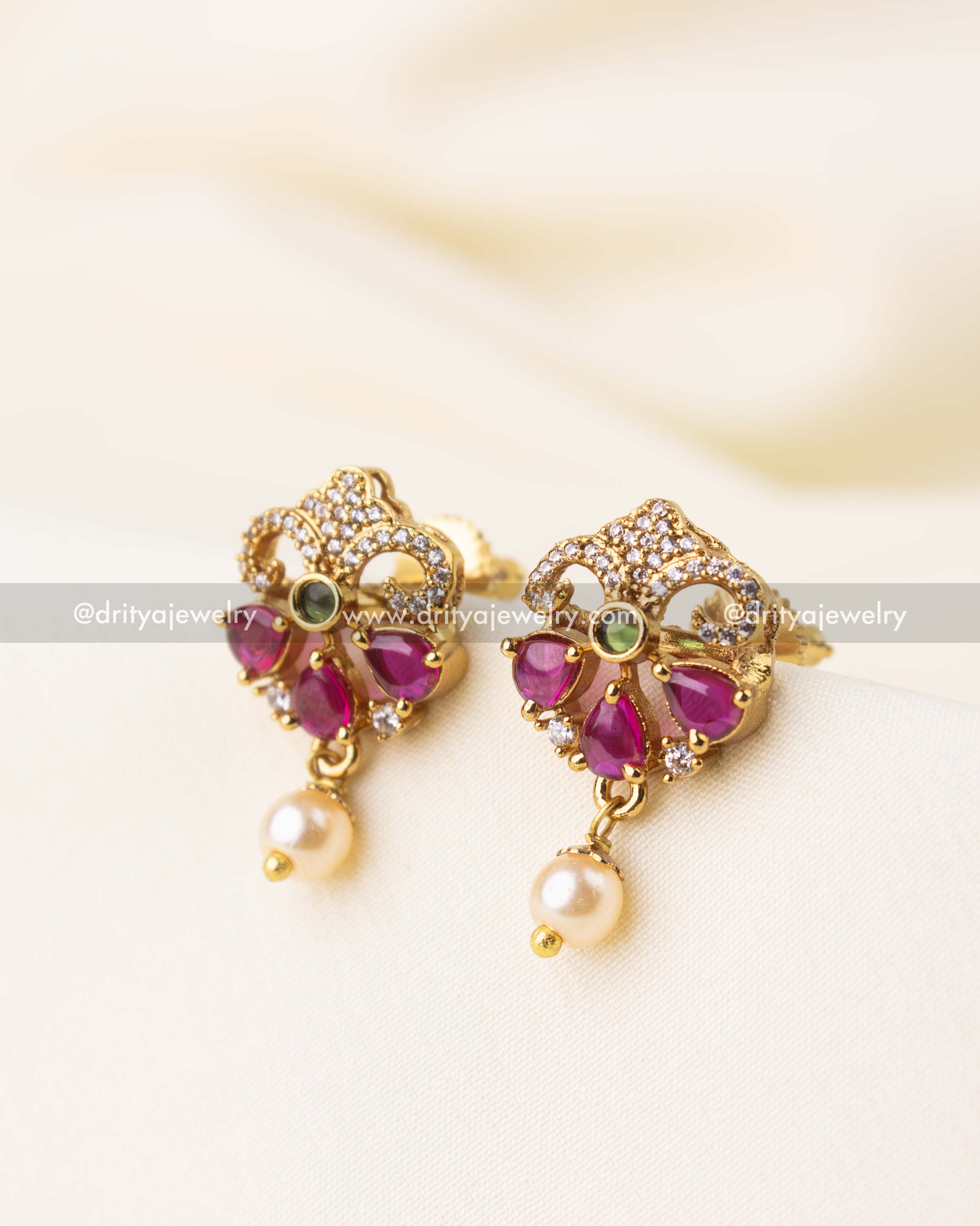 Gold-plated earrings featuring magenta pink stones, CZ accents, and a pearl drop.