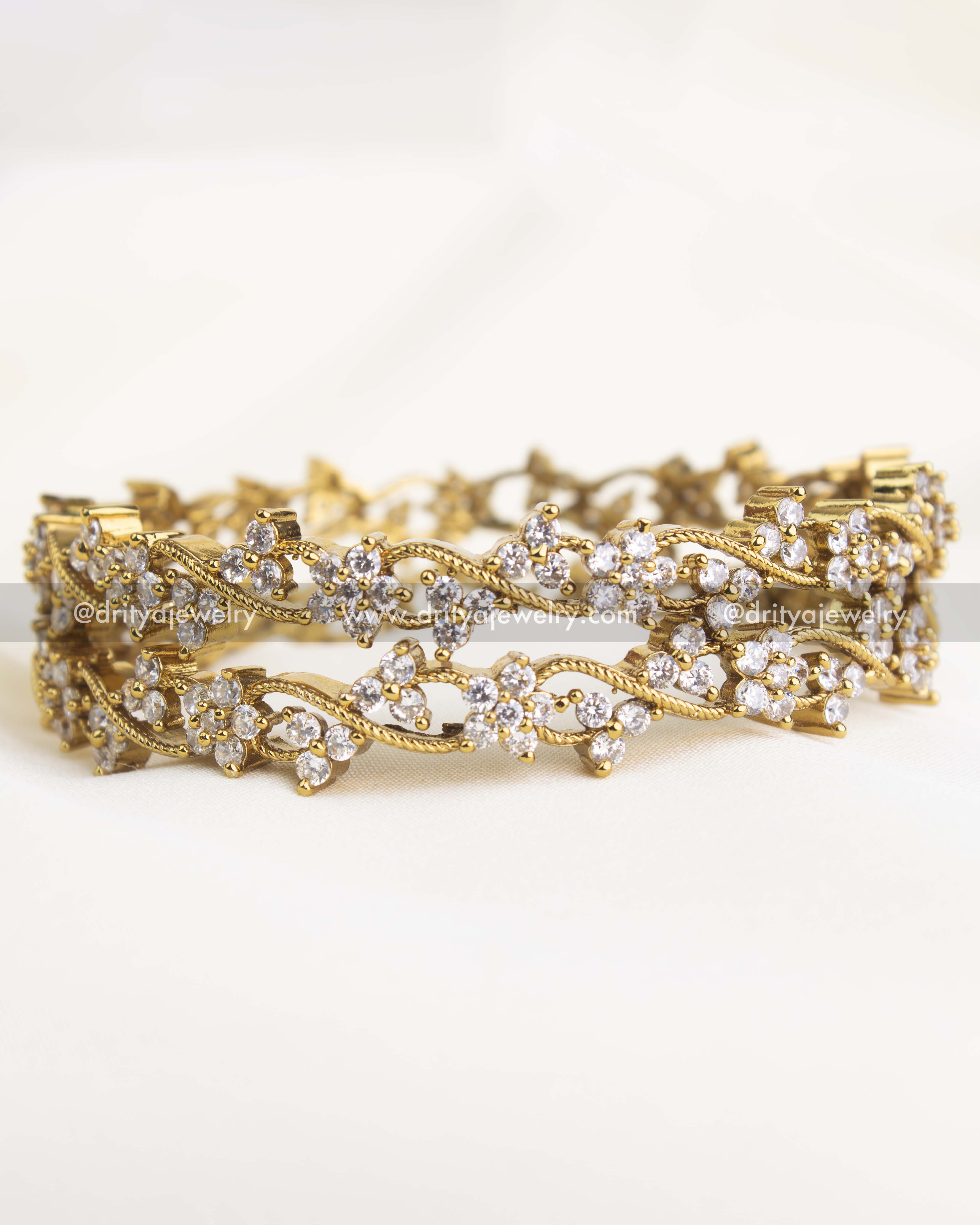 Pair of floral climber bangles with intricate craftsmanship and AD stones for a premium look.