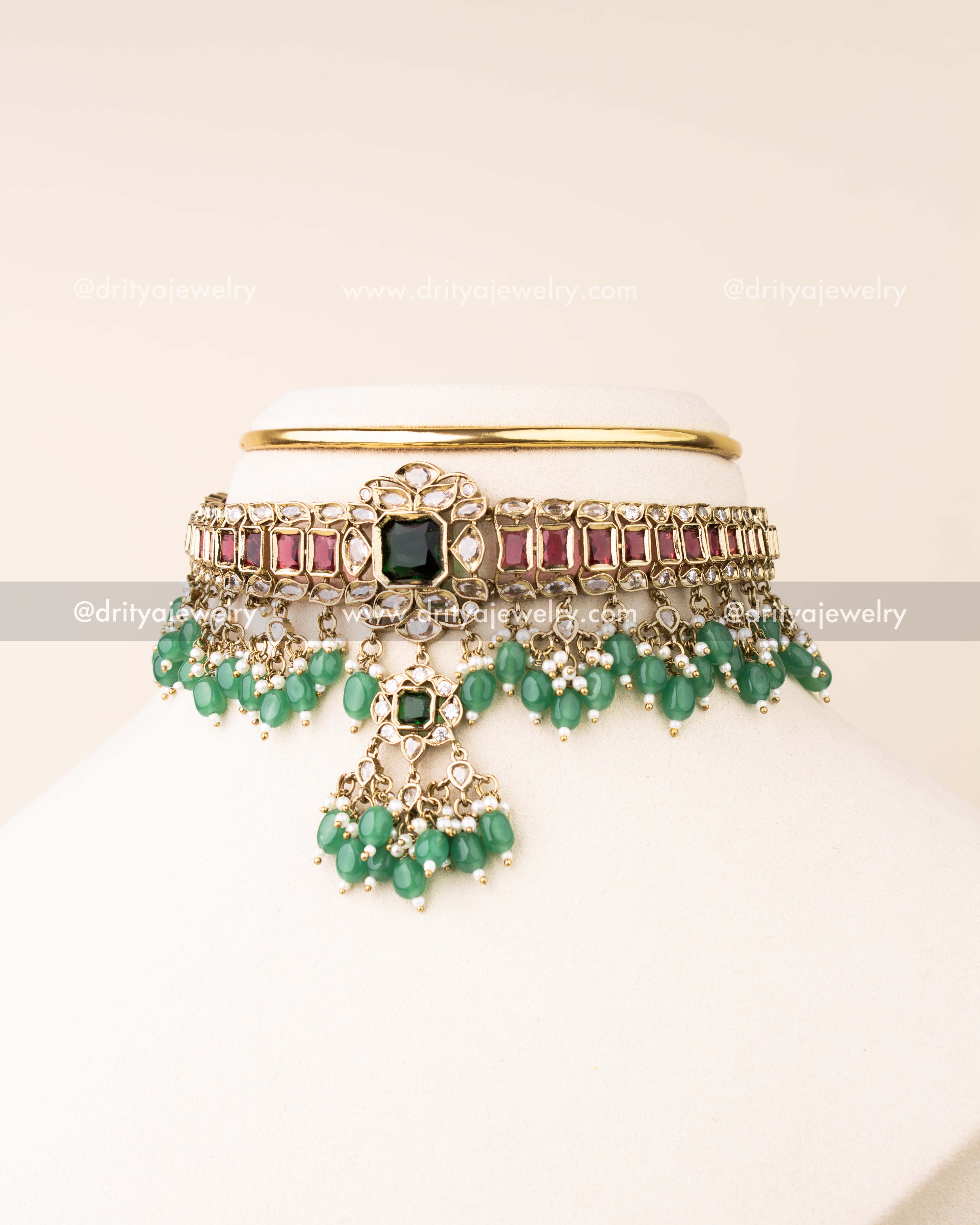 Premium choker featuring red stones, green pendant, reverse AD stones, and green bead drops.