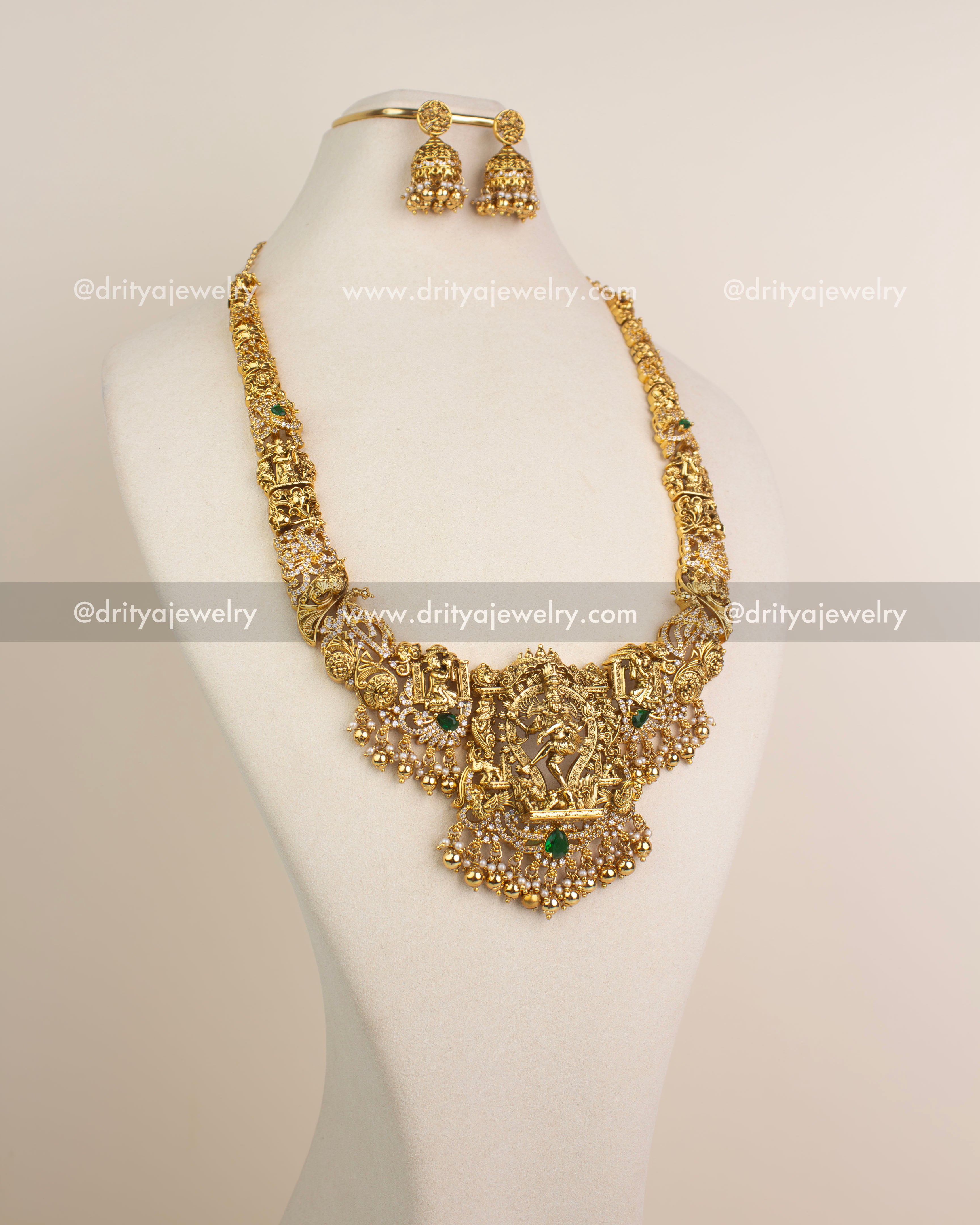 Antique gold Nakshi long haram with Nataraja pendant and matching jhumkas displayed on mannequin.