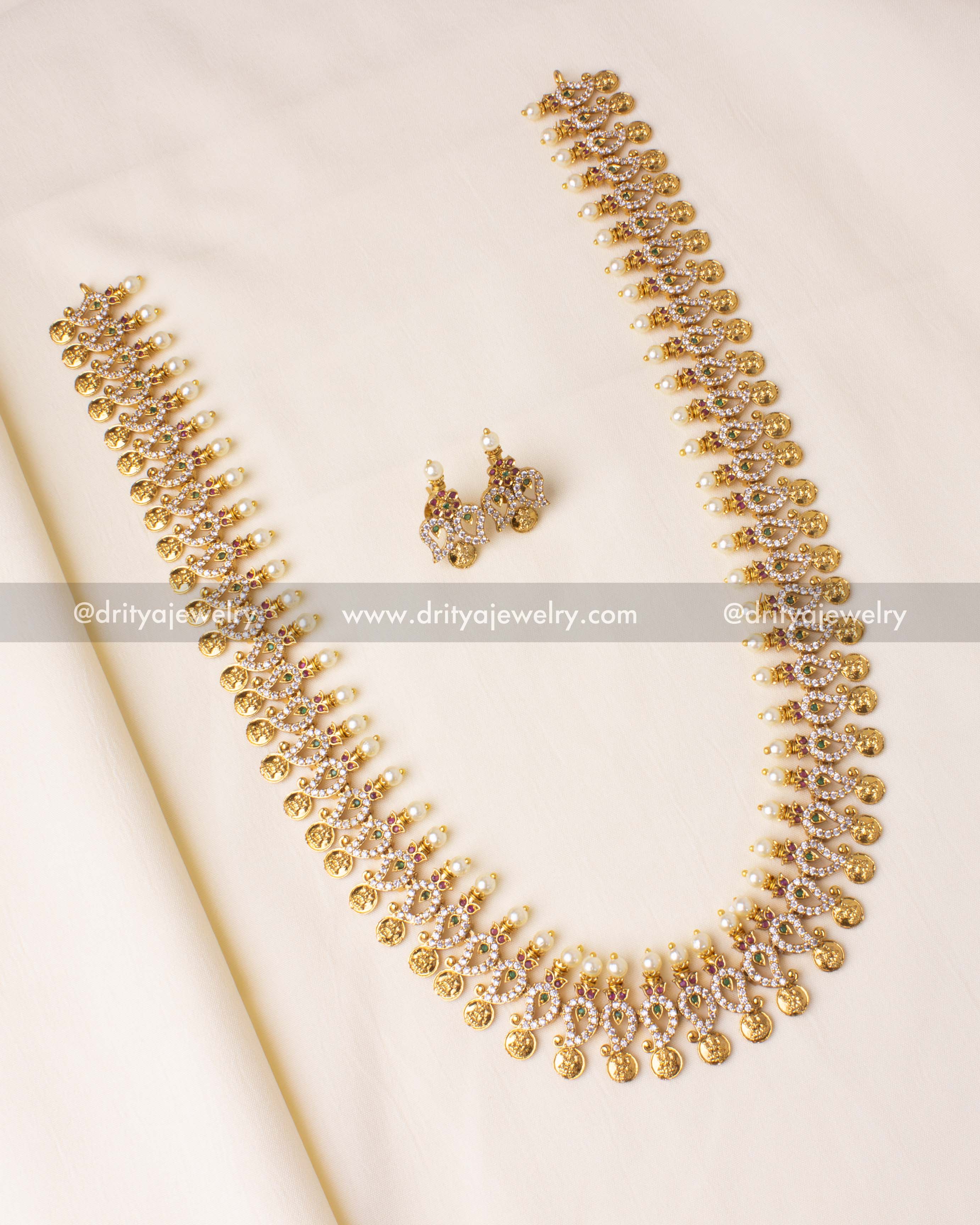 Gold-plated mango design long necklace with intricate CZ stones and pearl embellishments.