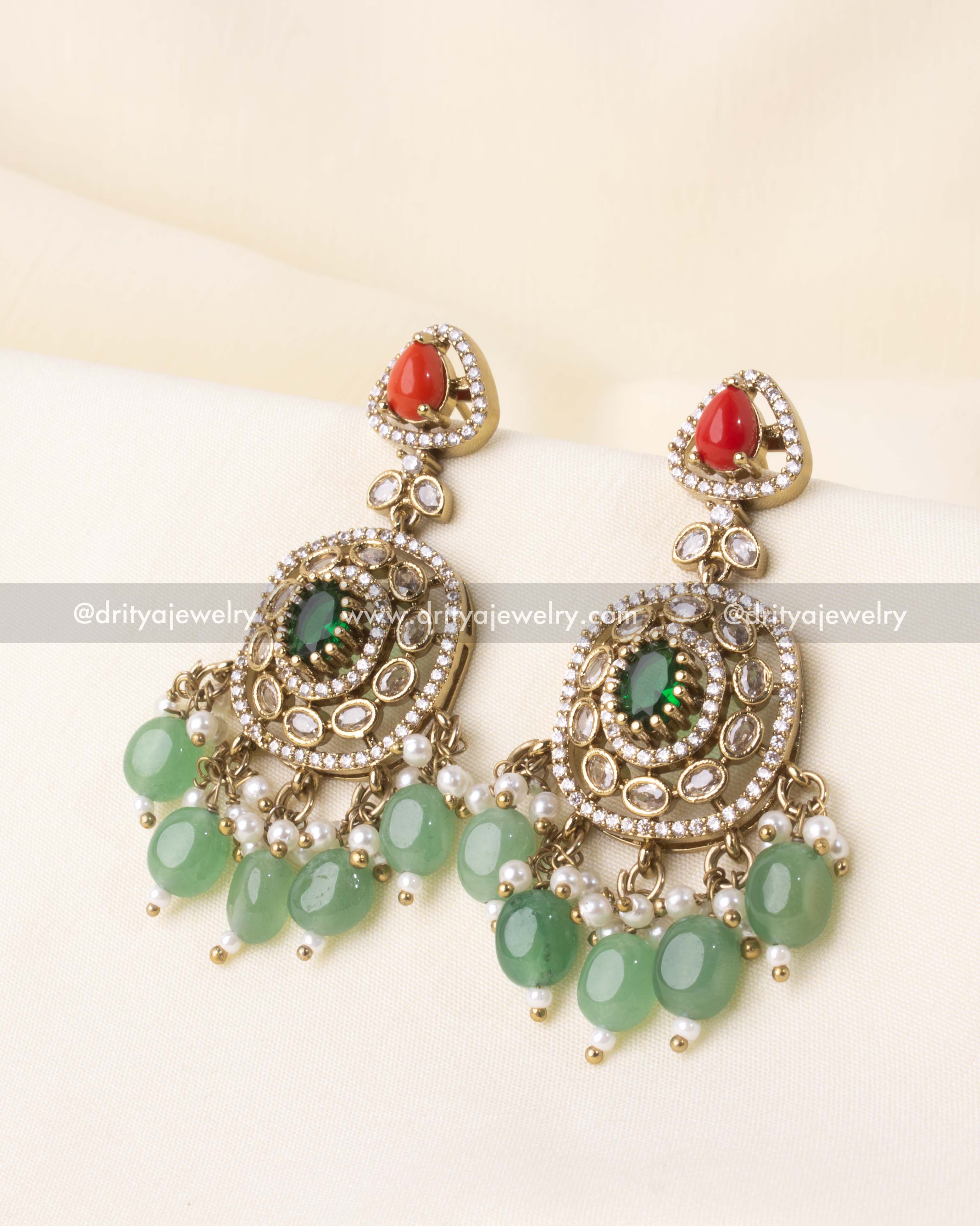 Pair of drop earrings with coral studs and green oval stones in a Victorian finish with pearl and bead accents.