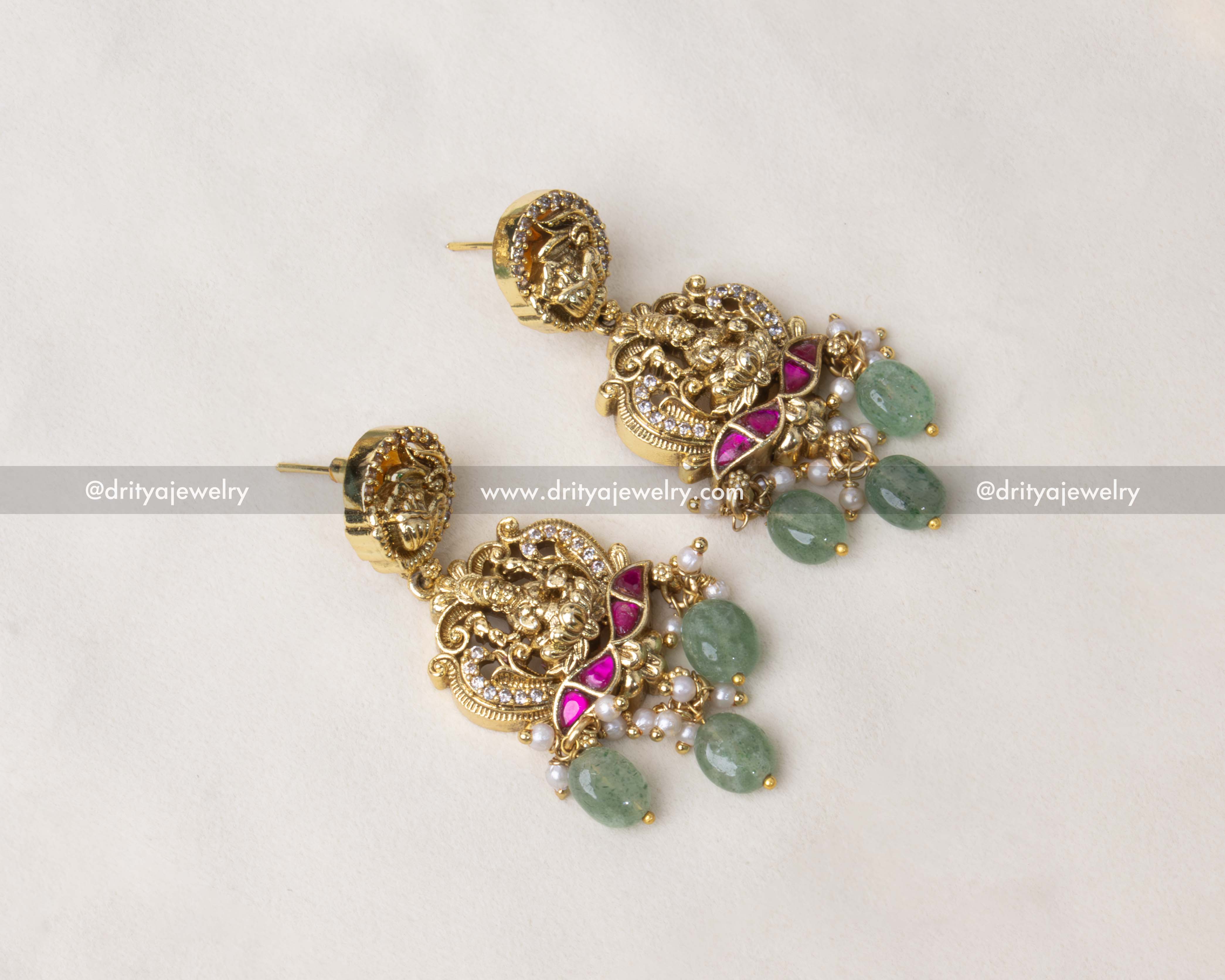 Jhumka-style earrings with nakshi motifs, kemp stones, and green bead drops.