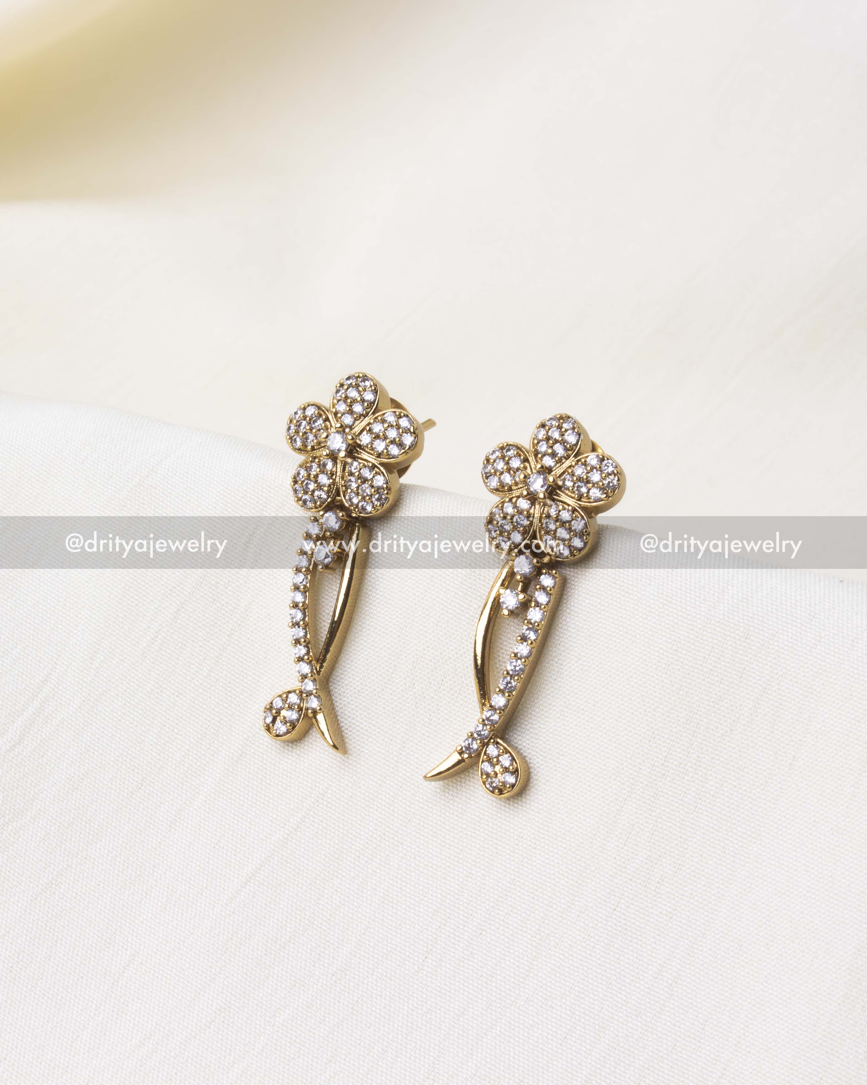 Gold-plated floral earrings with shimmering stones, part of a necklace set.