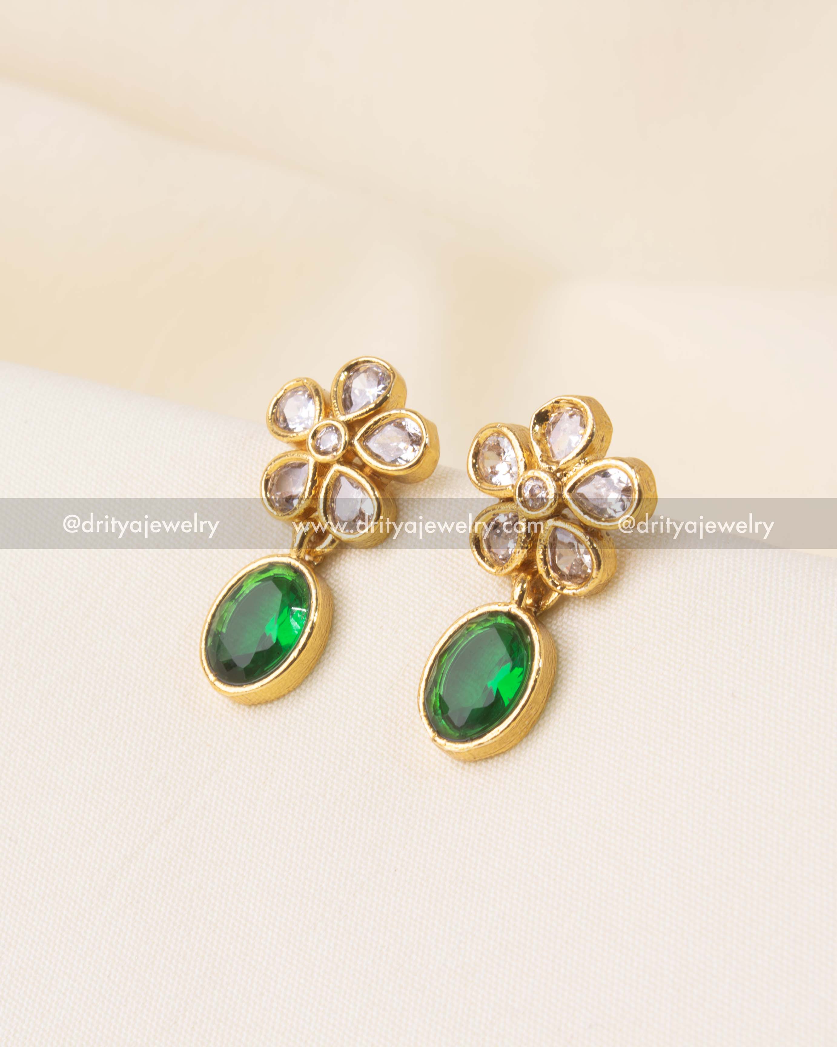 Stud earrings with kundan floral motif and emerald green teardrop stone.