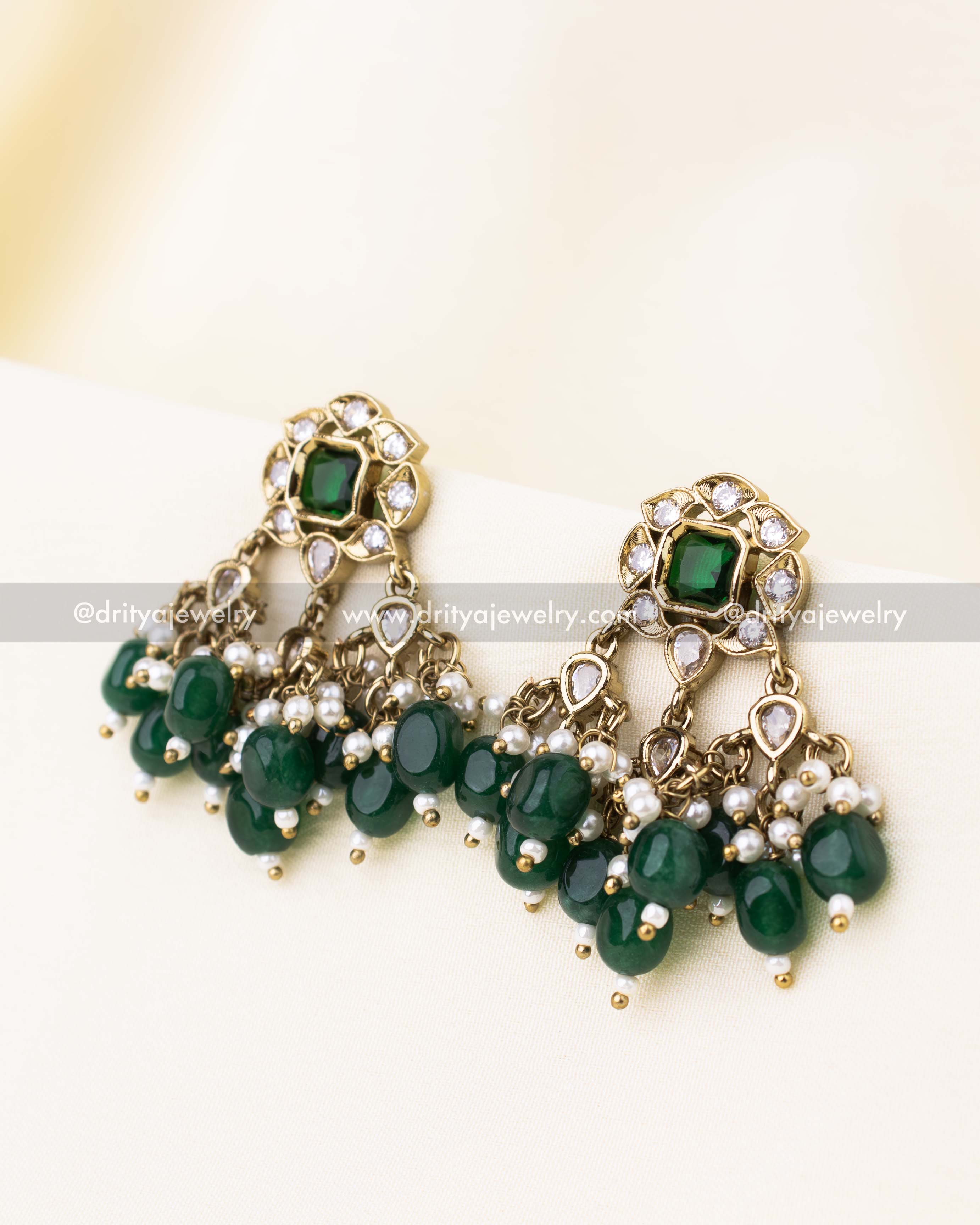 Stud earrings featuring green stones, reverse AD accents, and dangling emerald beads.