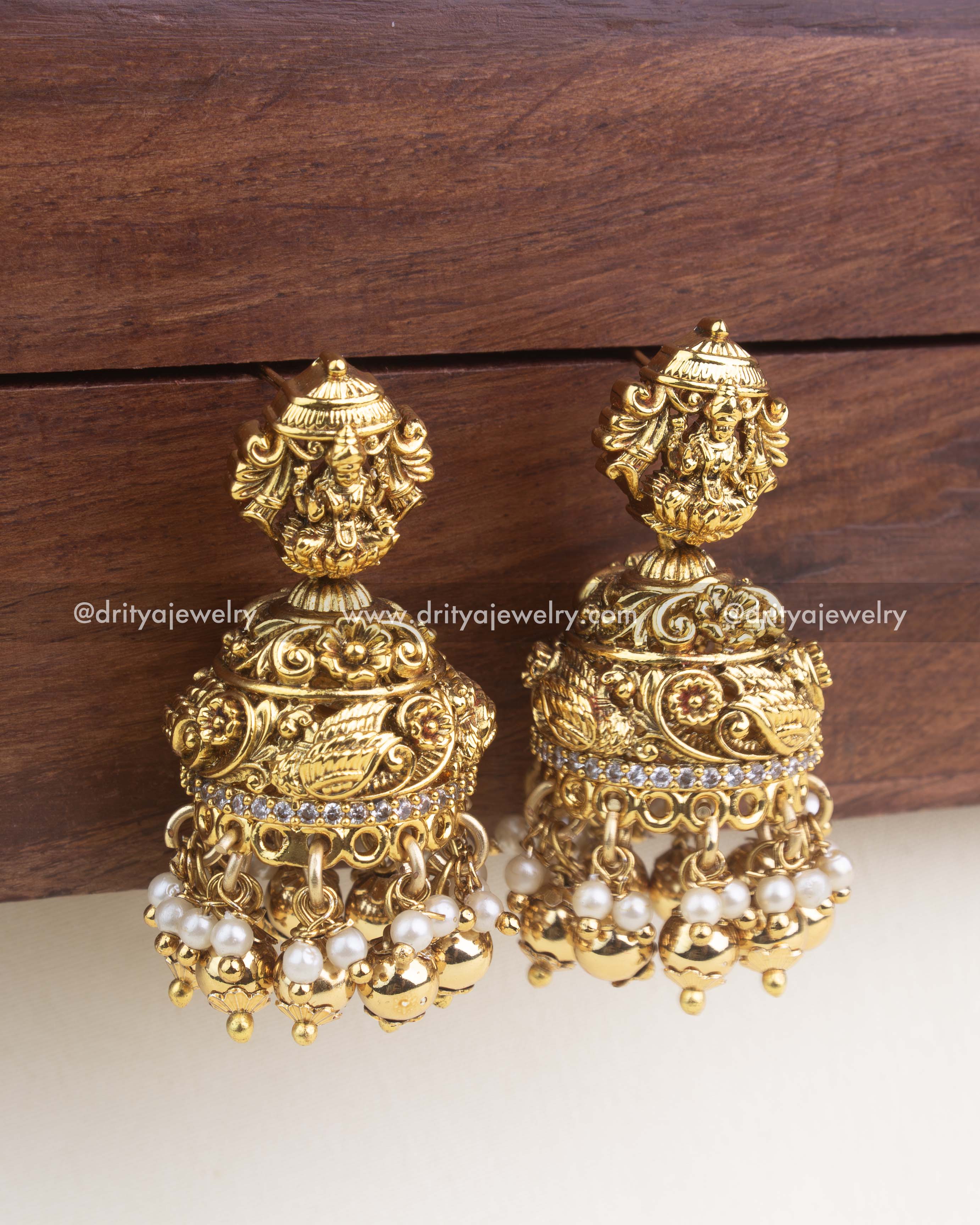 Temple-style nakshi jhumka earrings with goddess Lakshmi top and pearl-gold ghungroo hangings.