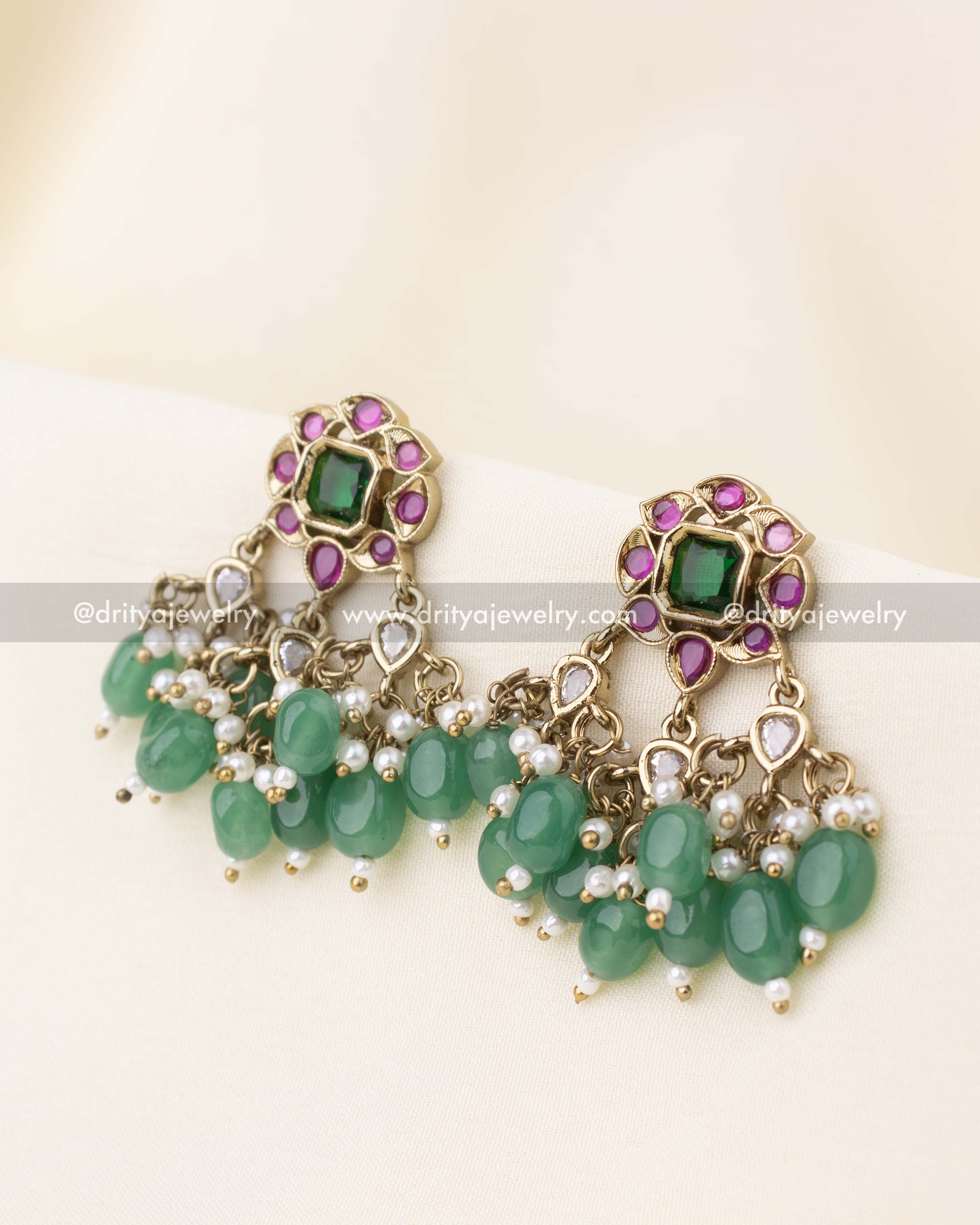 Stud earrings with red-green combination and dangling green bead accents.