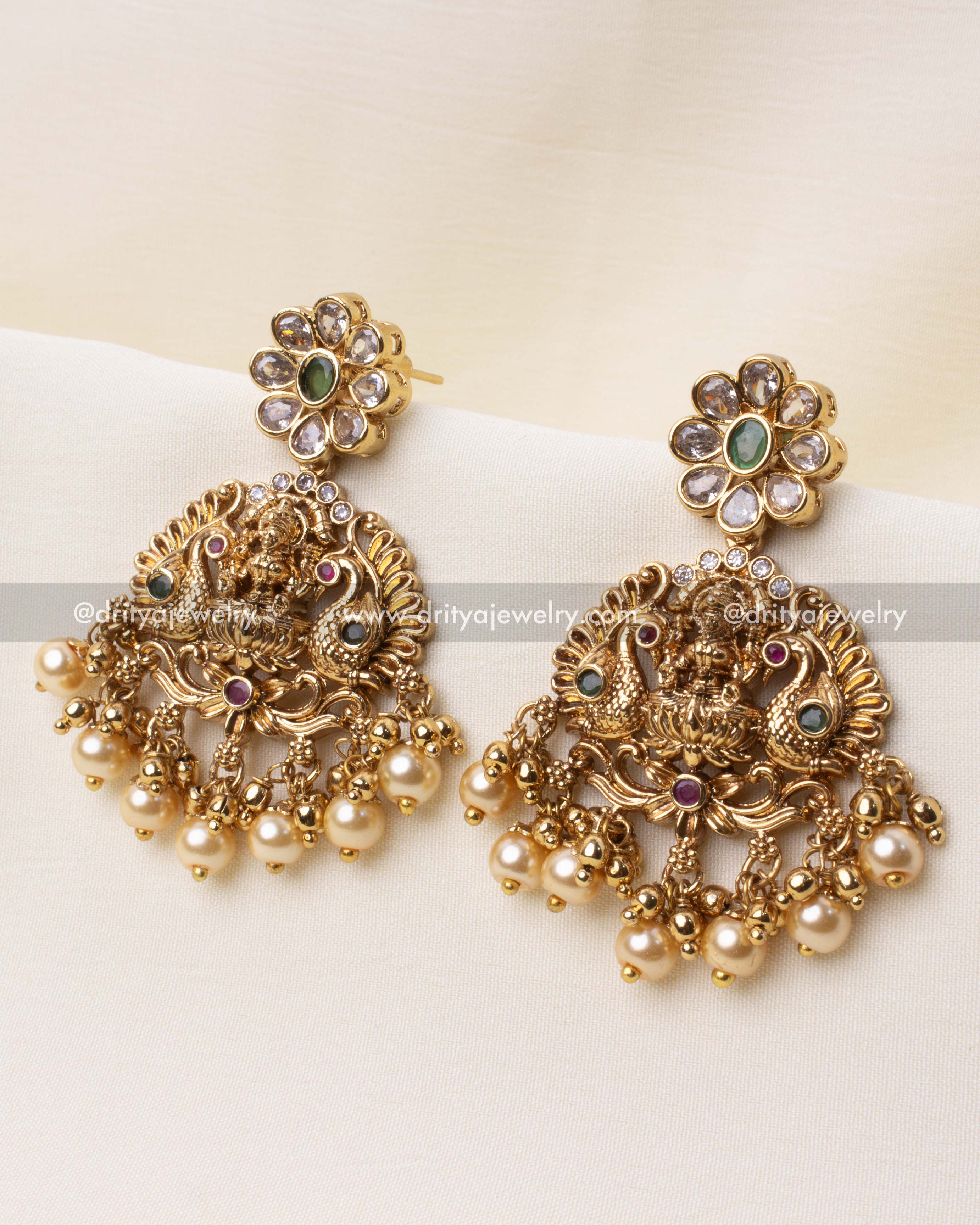 Gold-plated temple earrings featuring floral tops and goddess motifs with pearl drops.
