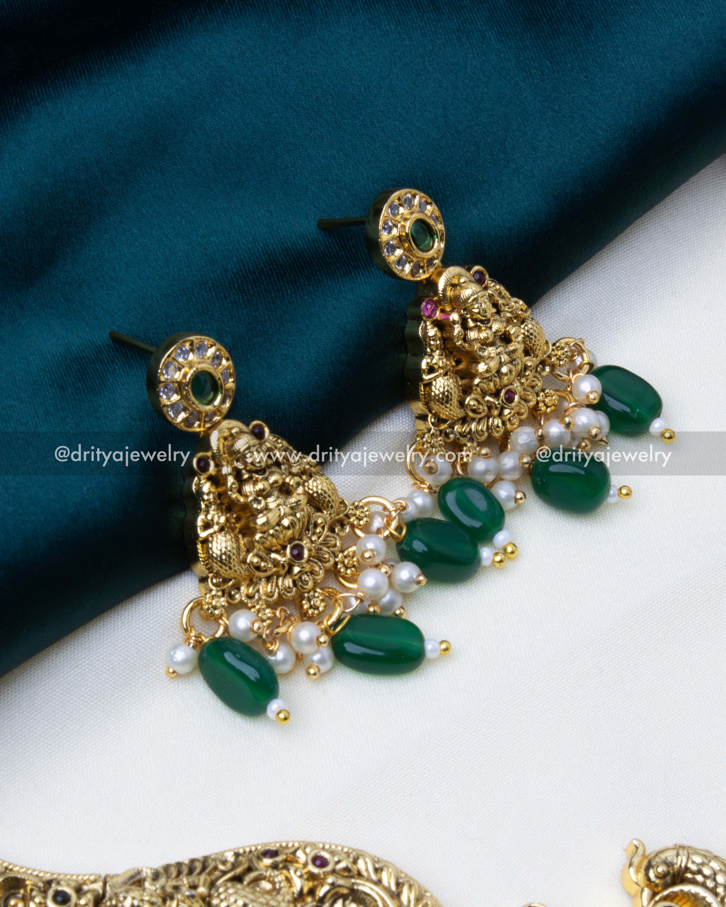 Temple-themed earrings in antique gold finish adorned with green beads and pearls.