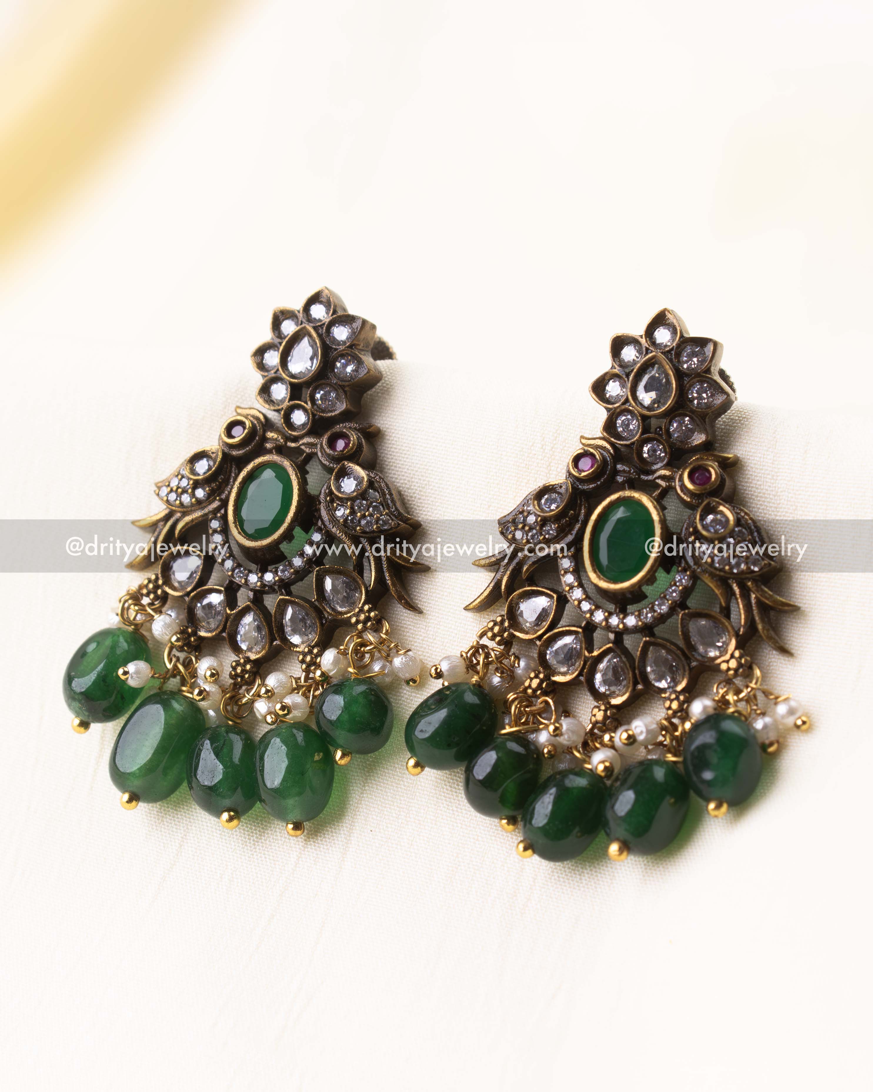 Victorian-style earrings with floral top, green center stone, and pearl-green bead drops.