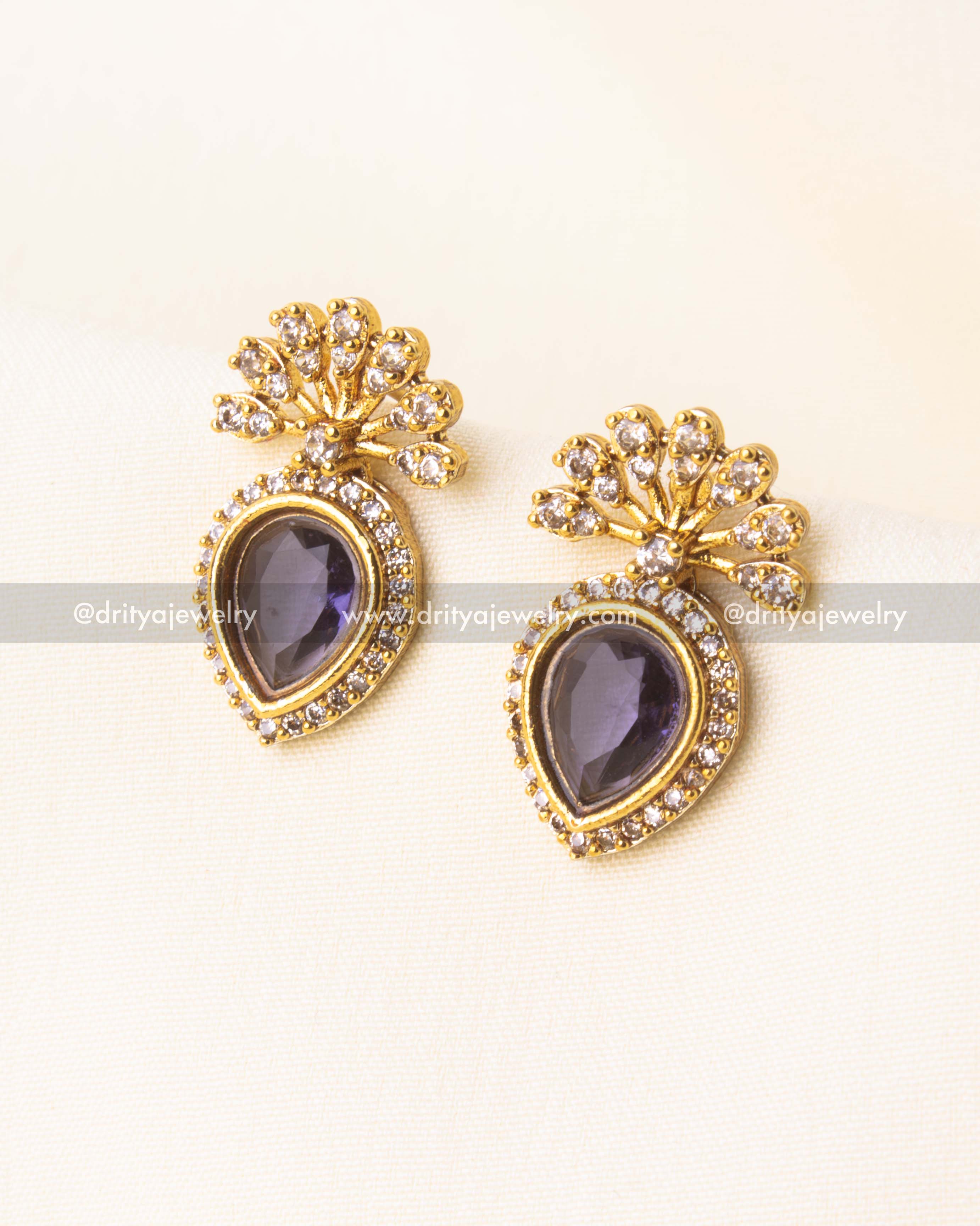 Gold-plated drop earrings with violet stones and floral diamond motifs.