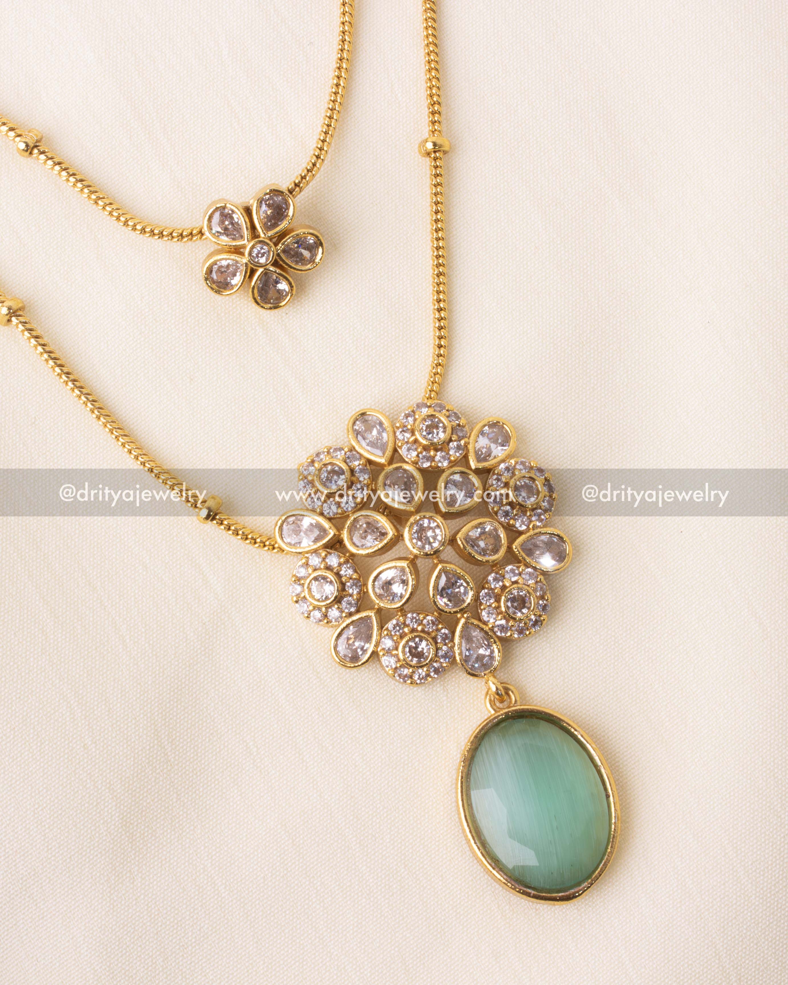 Detailed view of emerald green pendant with floral kundan centerpiece.