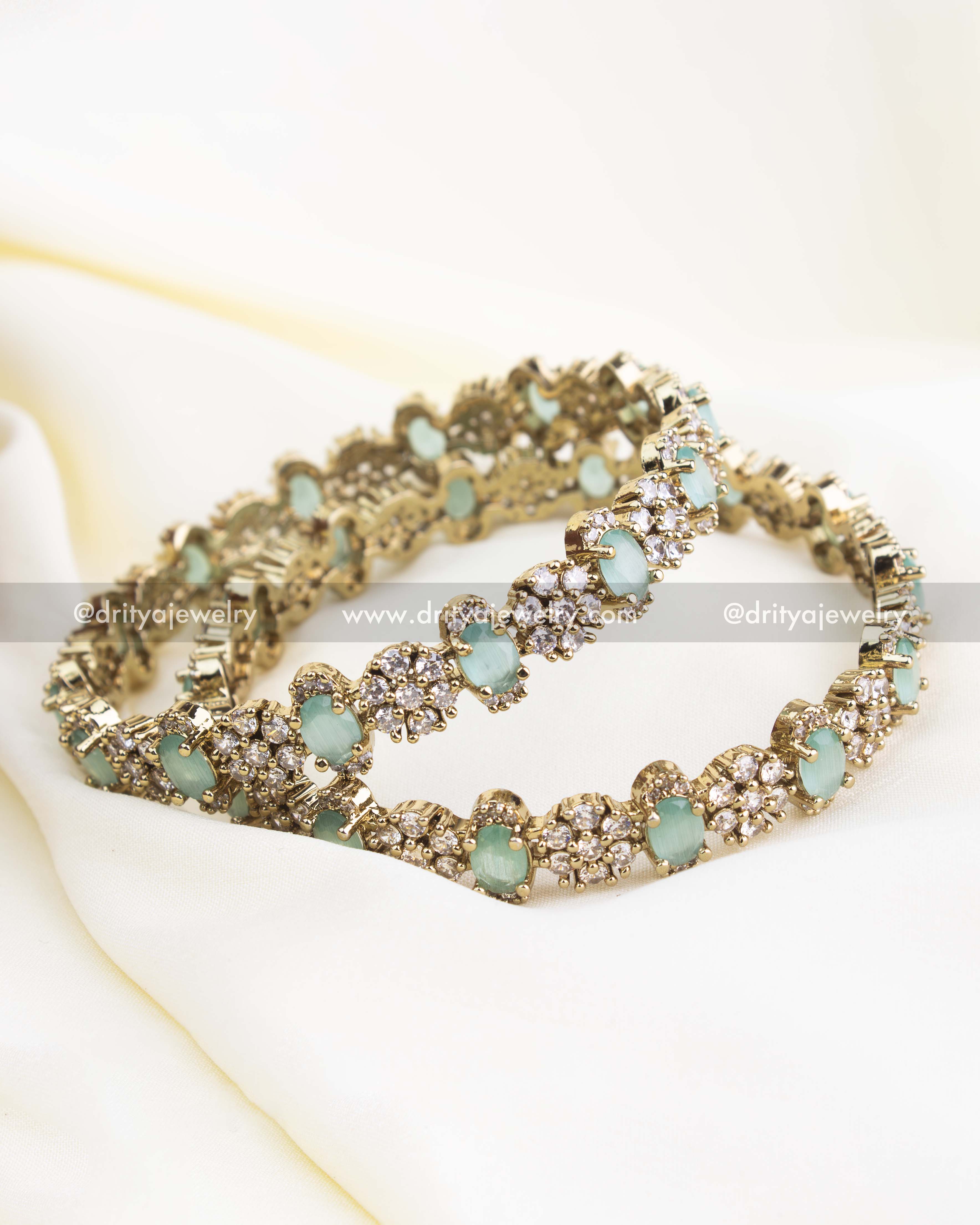 Victorian gold bangles with mint green oval stones and CZ cluster embellishments.