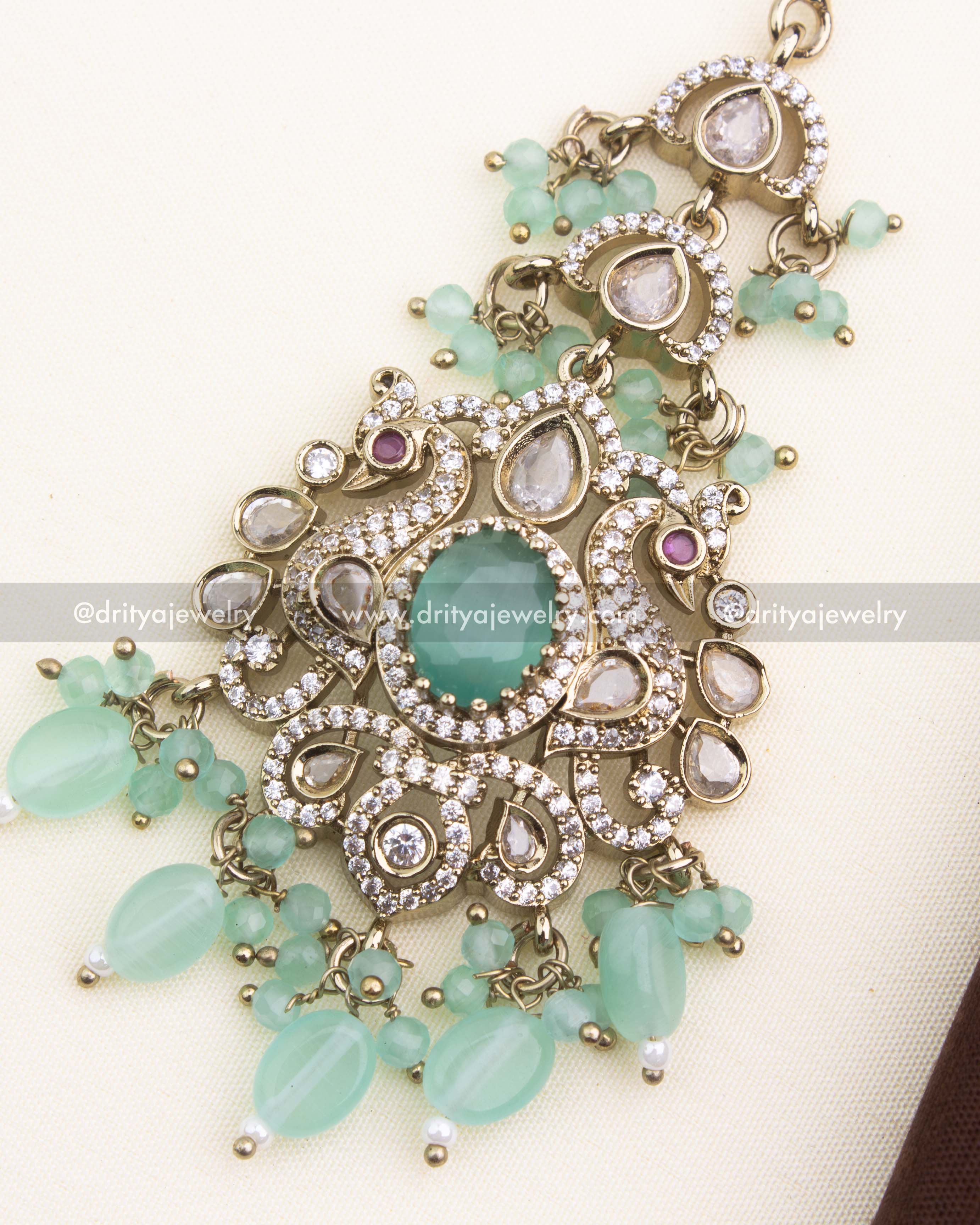 Close-up of mint green center stone, AD kundan accents, and Victorian gold finish