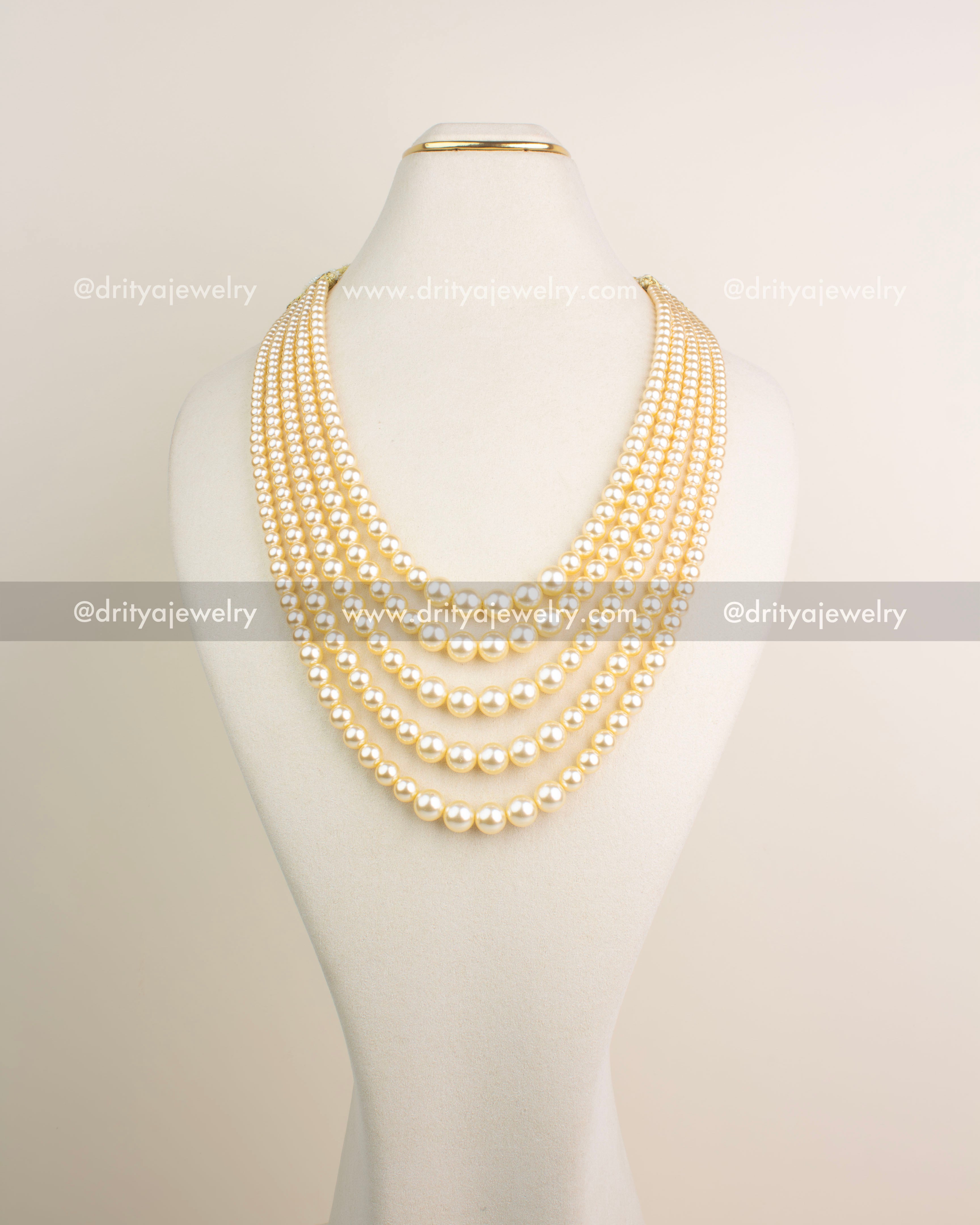 Elegant seven-layer pearl necklace with classic gold undertone for festive and bridal wear.