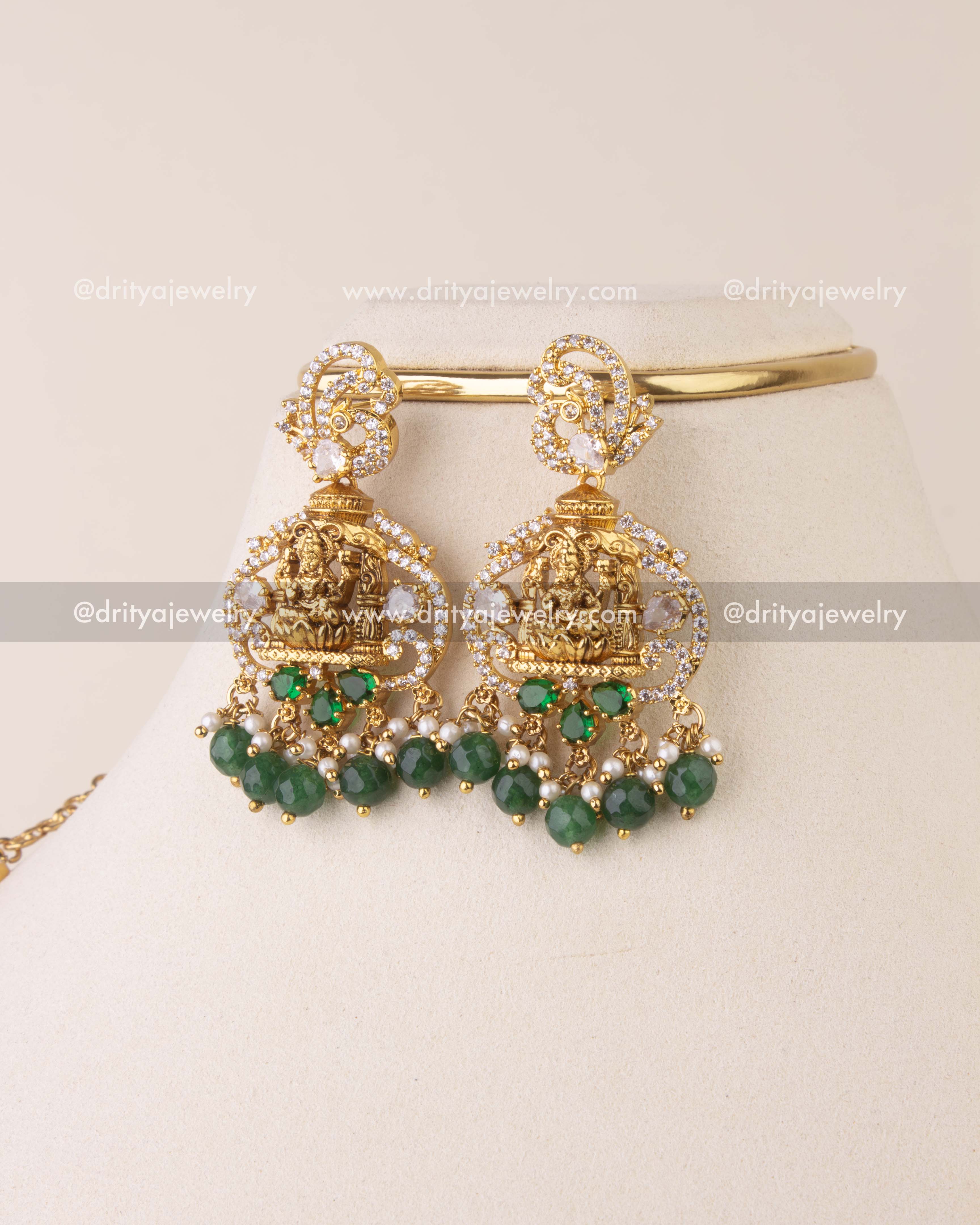 Pair of temple-style earrings with Goddess Lakshmi detailing, CZ stones, and green beads.