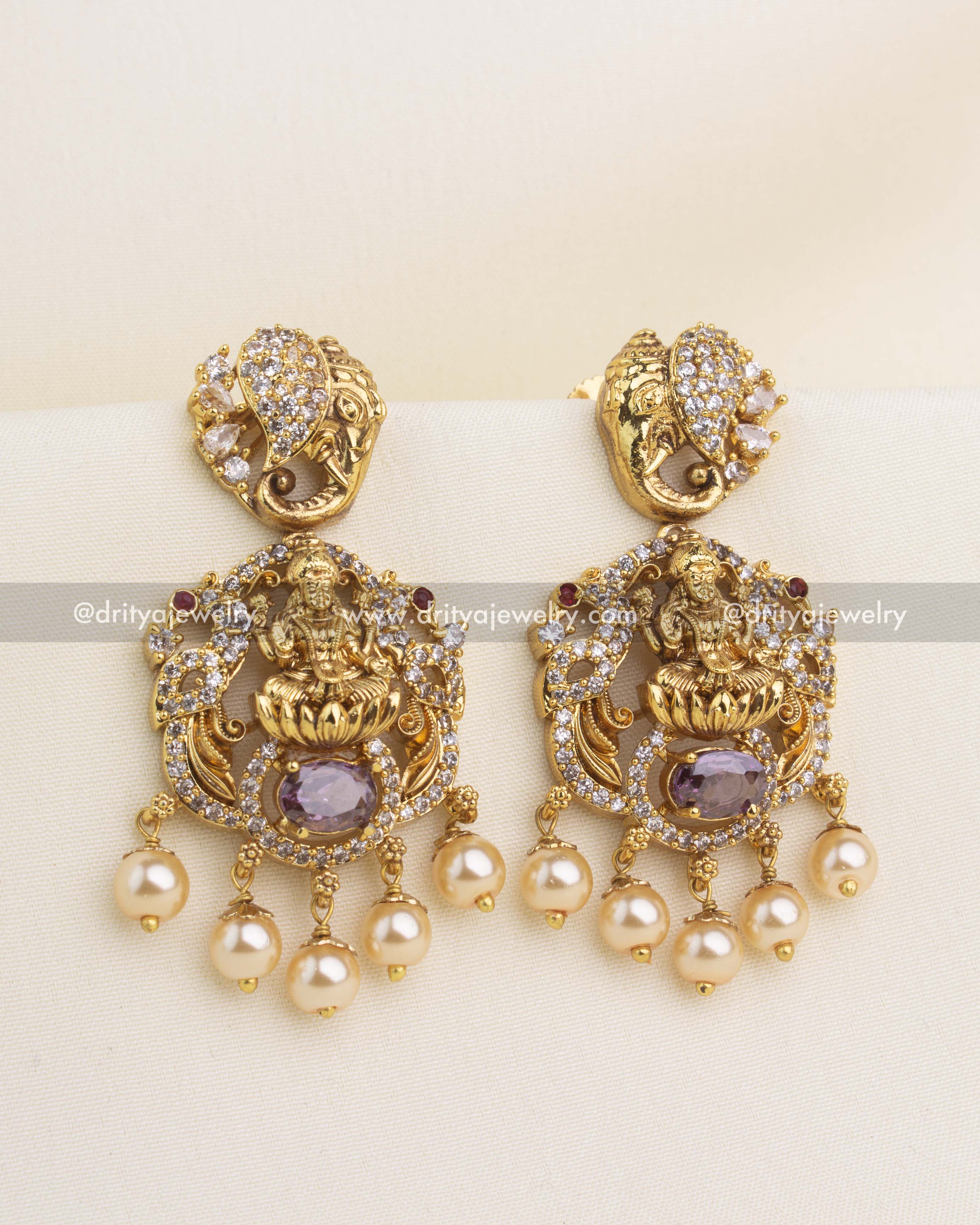 Premium gold nakshi temple dangler earrings with Lakshmi motif, purple stone, and pearl drops.