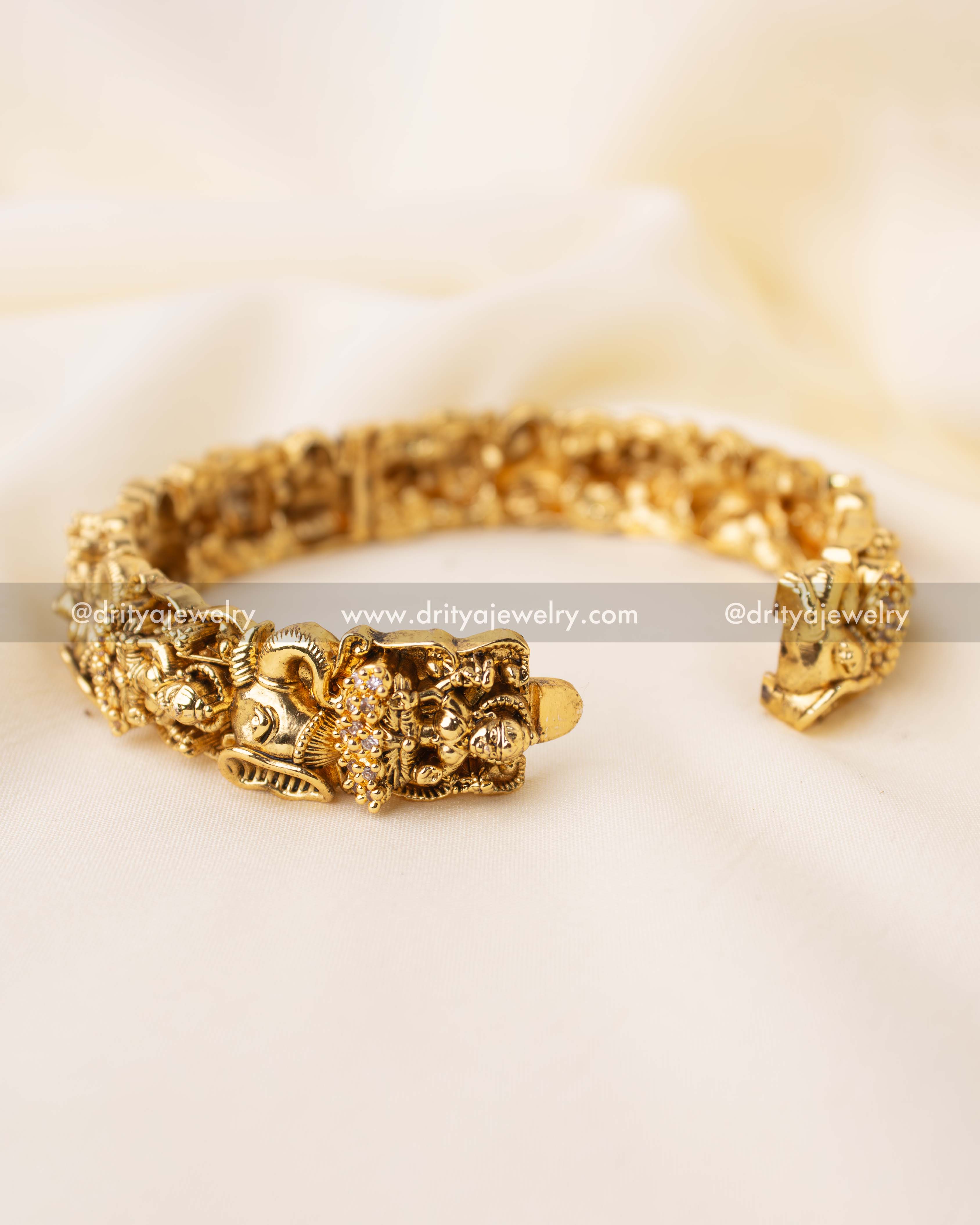 Premium temple-style openable bangle with embossed deity figures and clasp mechanism.
