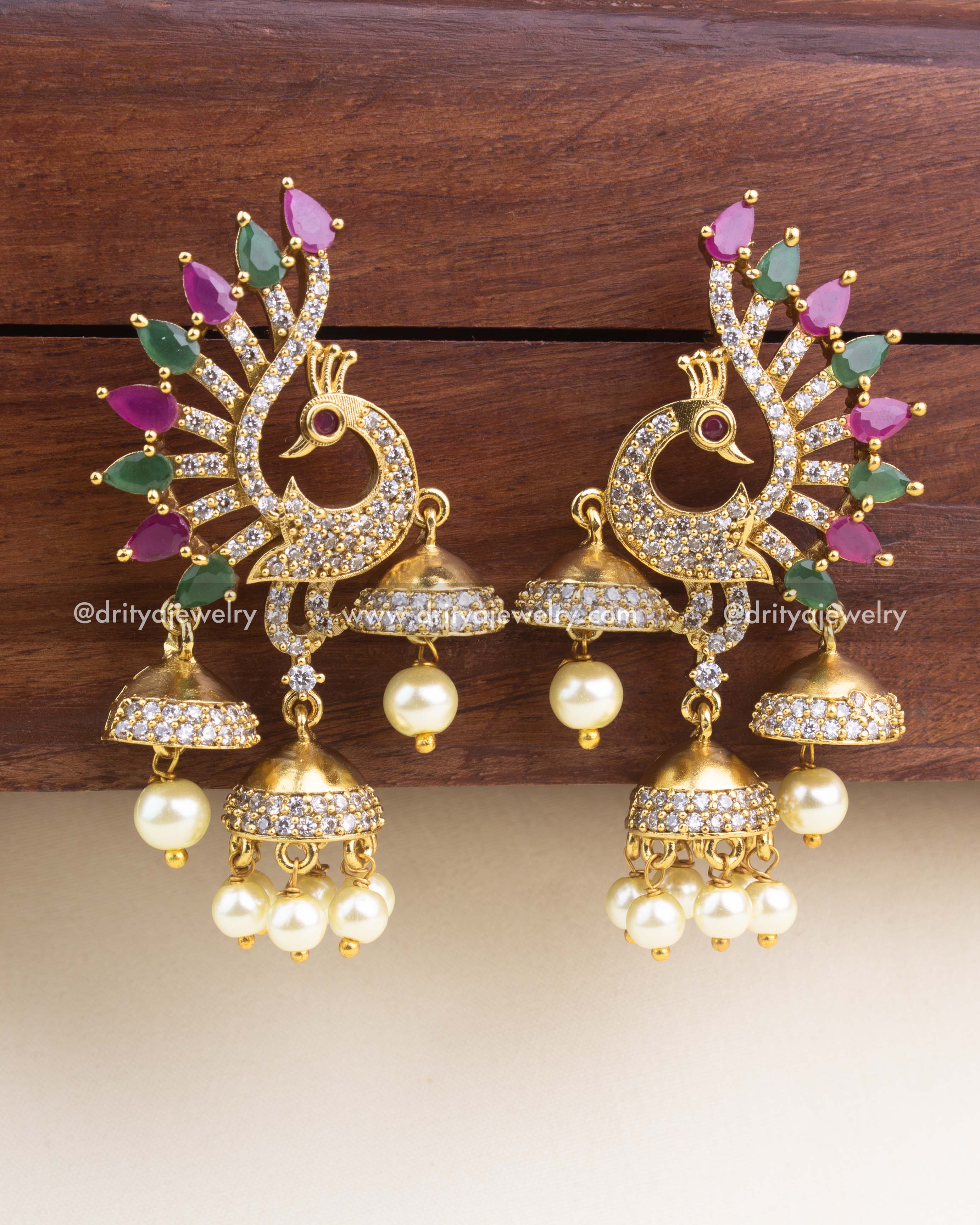 Peacock design CZ earrings with multicolor feather stones and hanging pearl clusters.