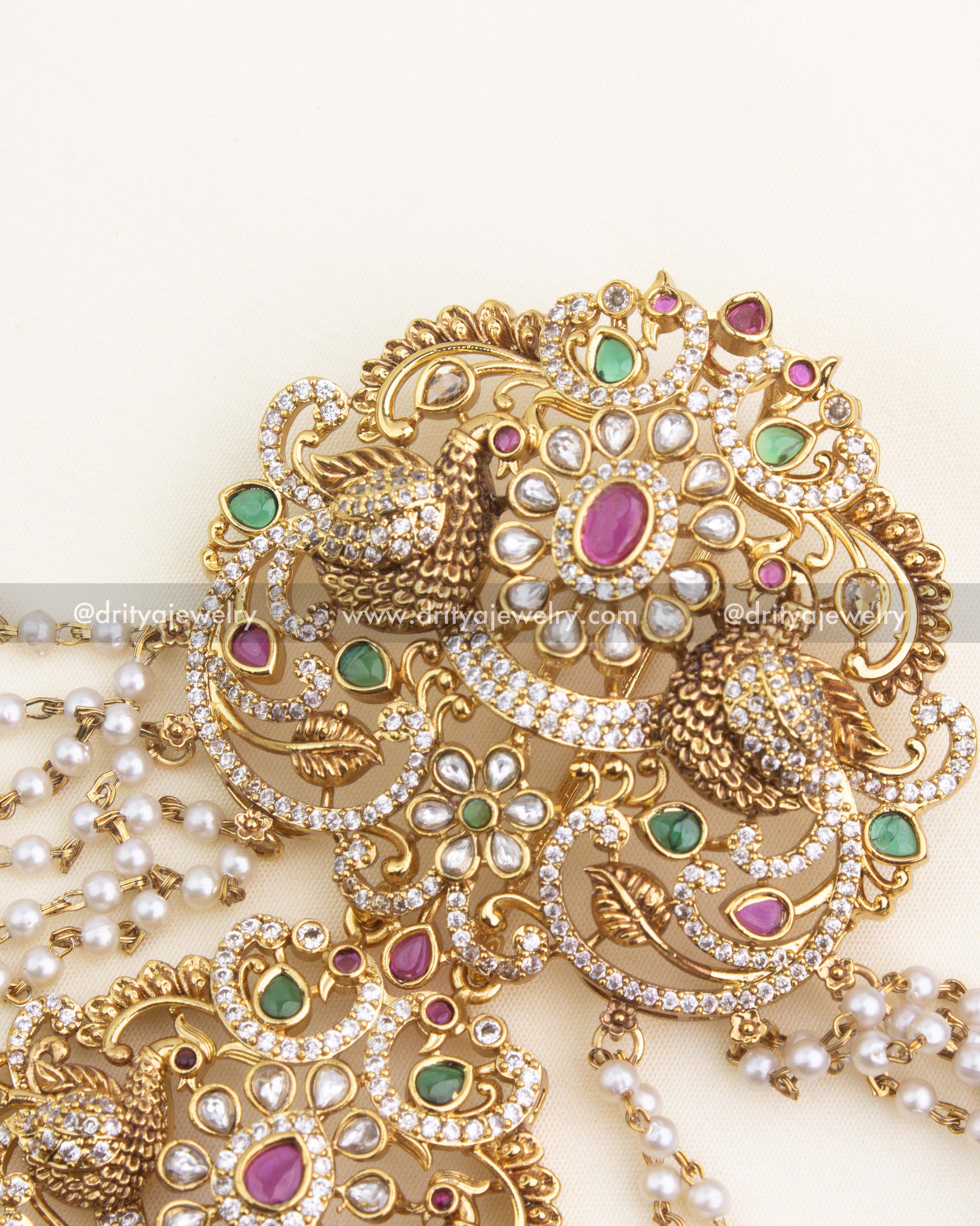 Pearl champaswaralu strands with antique jhumka drop and textured bead detailing.