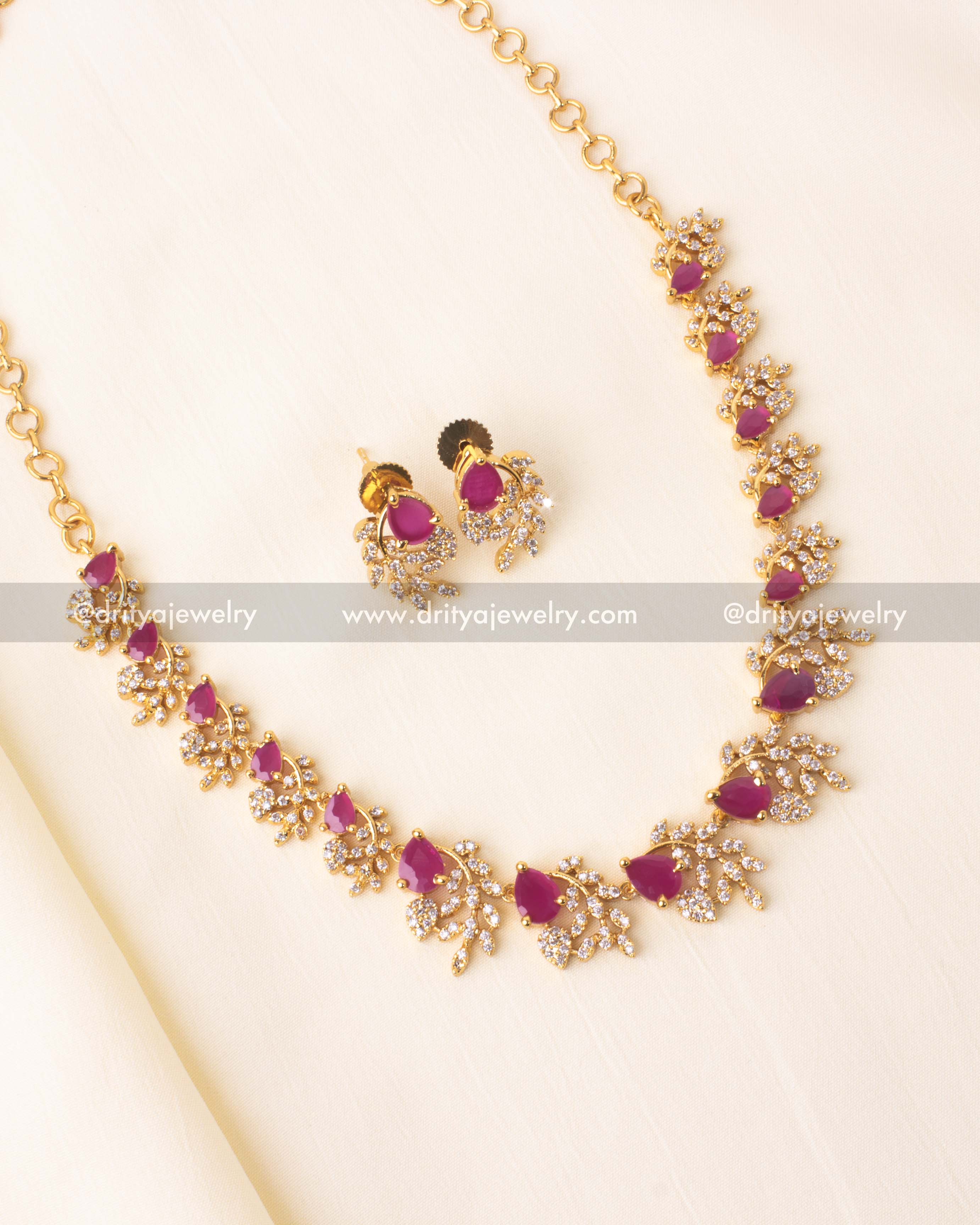 Gold-plated short necklace with pink teardrop stones and matching stud earrings.