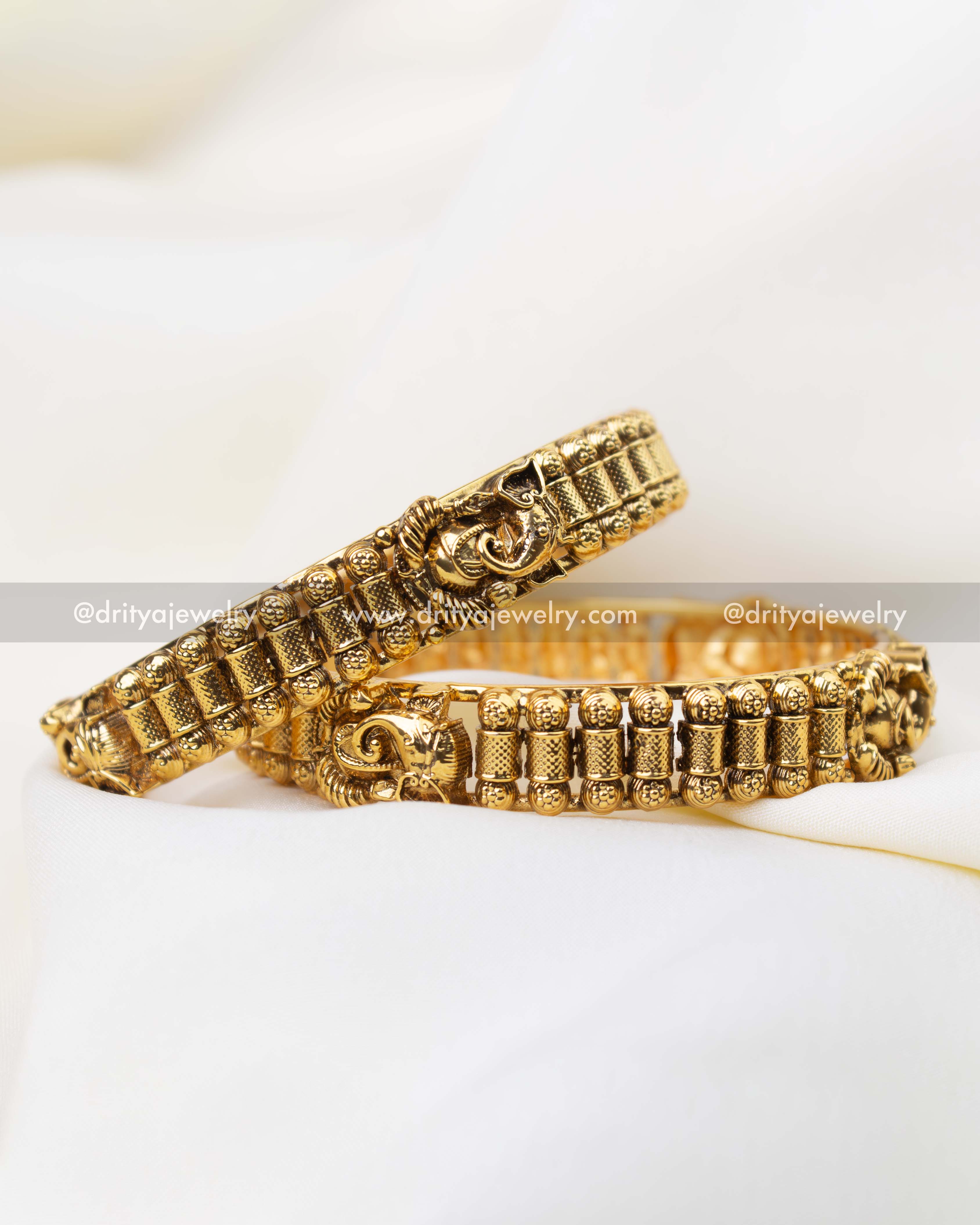 Traditional antique gold bangle pair with Lord Ganesha motif and temple detailing