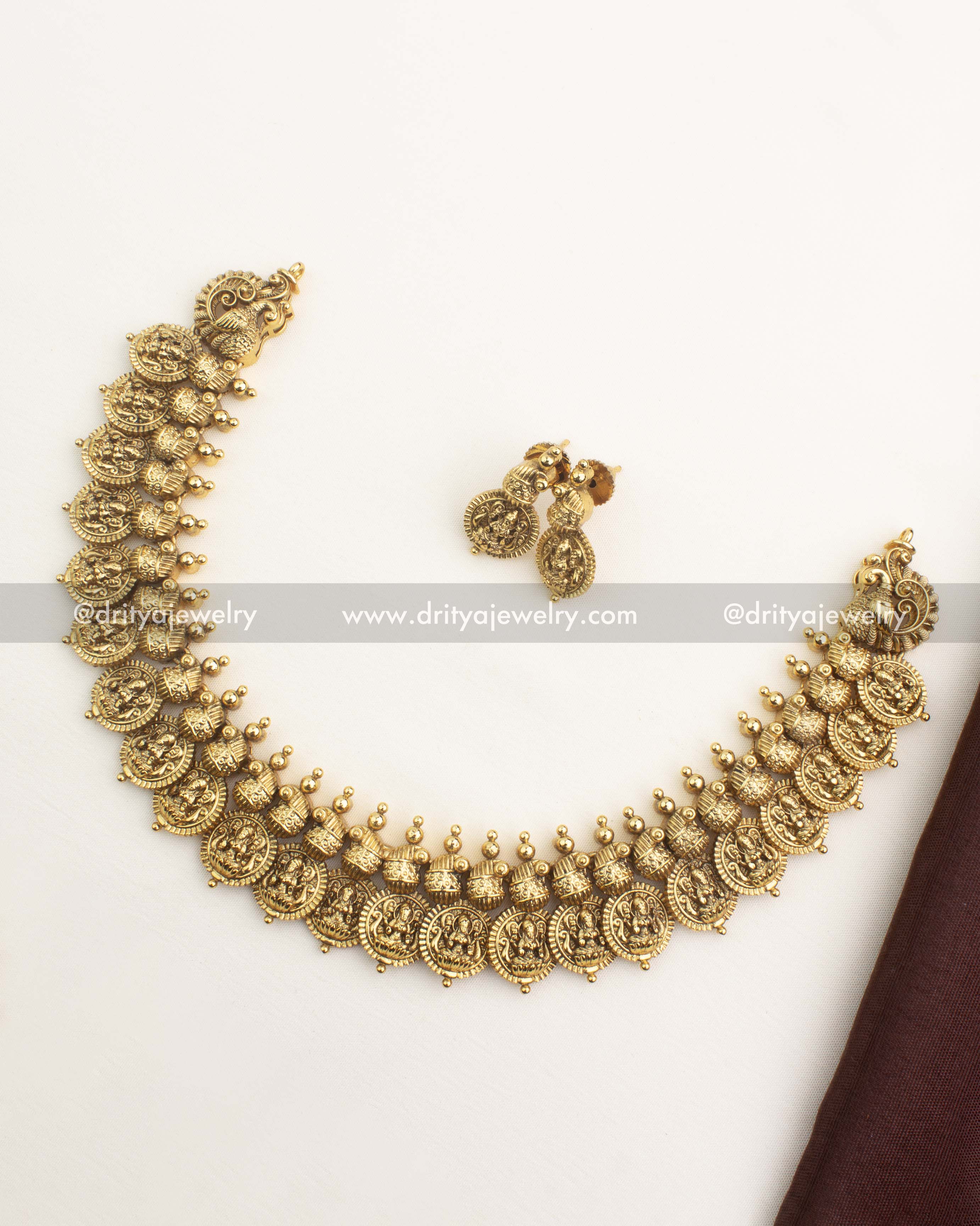 Antique gold Kasulu short necklace with Lakshmi coin motifs and matching earrings from Dritya Jewelry.