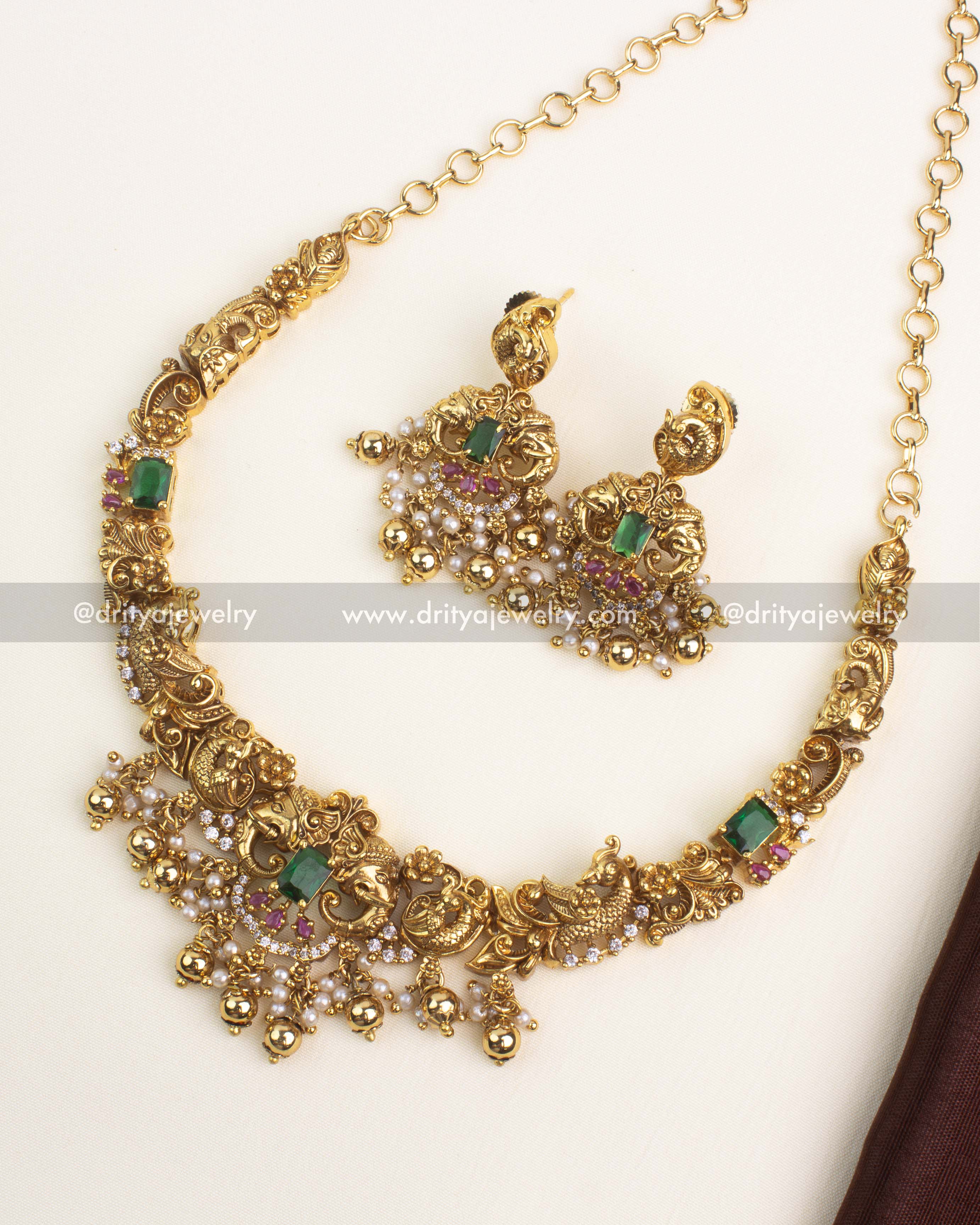 Antique gold-plated short necklace set with peacock and elephant motifs, emerald green stones, and ruby accents.
