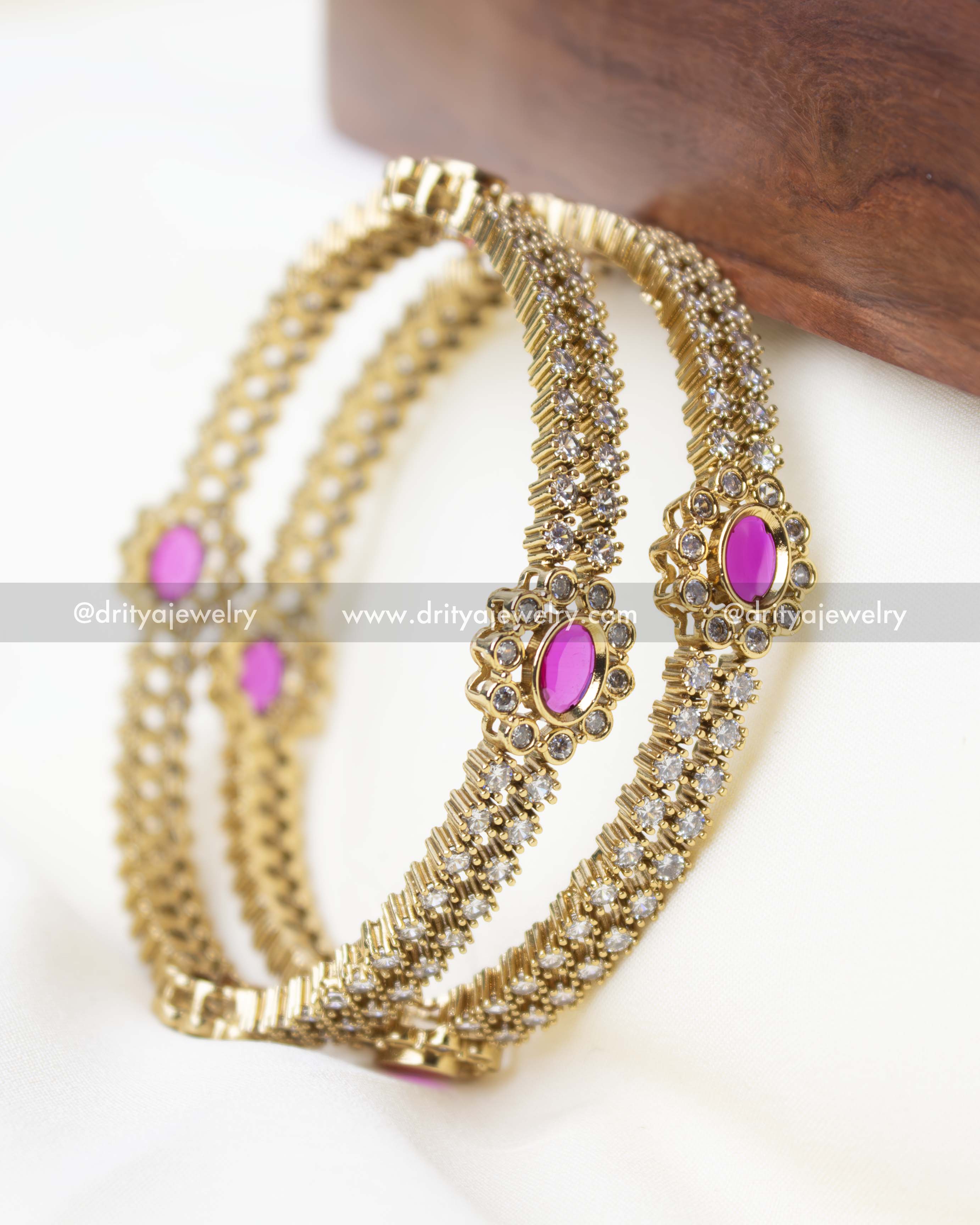 Premium gold-plated bangle set featuring pink stone accents and intricate floral detailing.