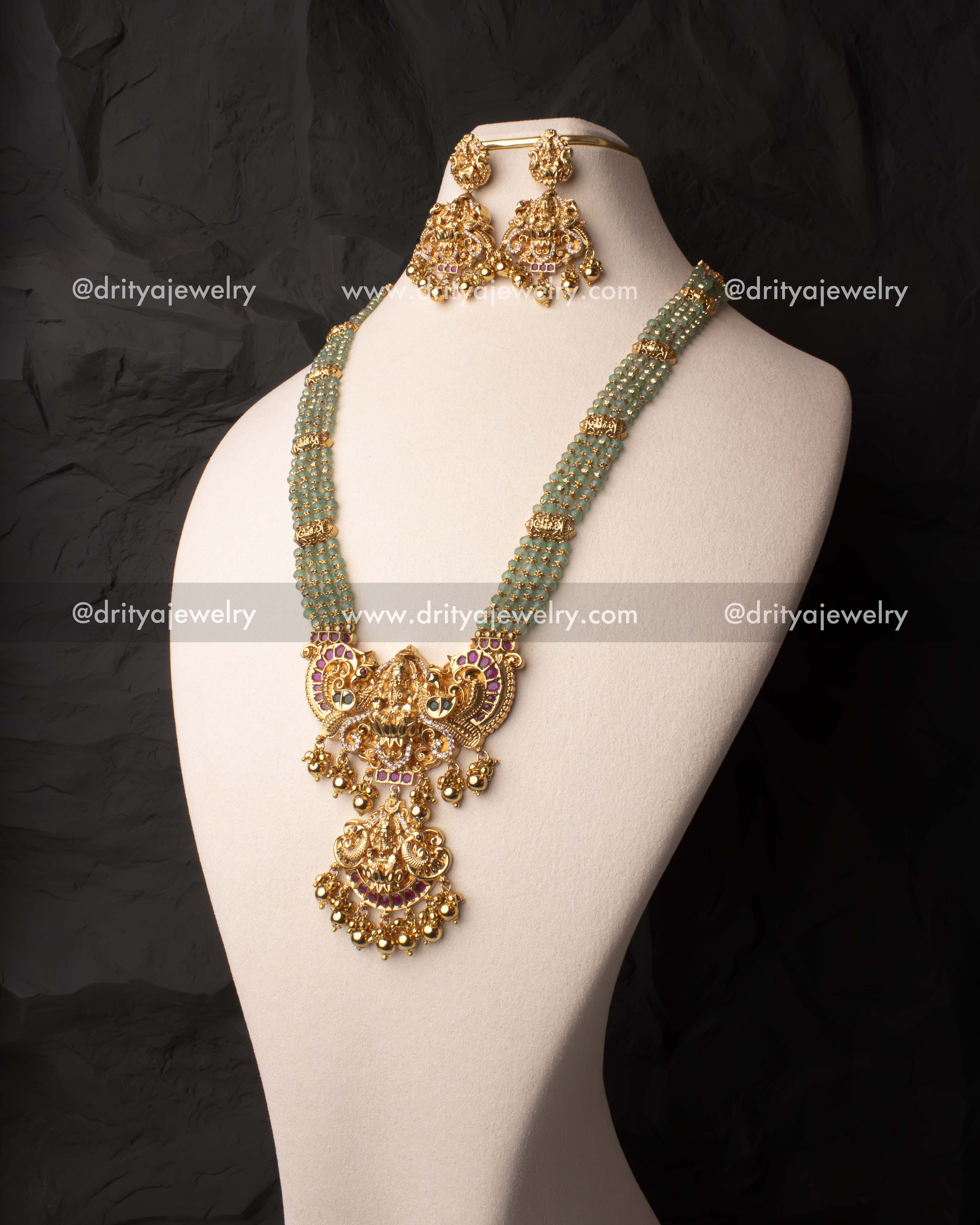 Elegant green beads haram set with a gold-plated Lakshmi Devi pendant and matching earrings.