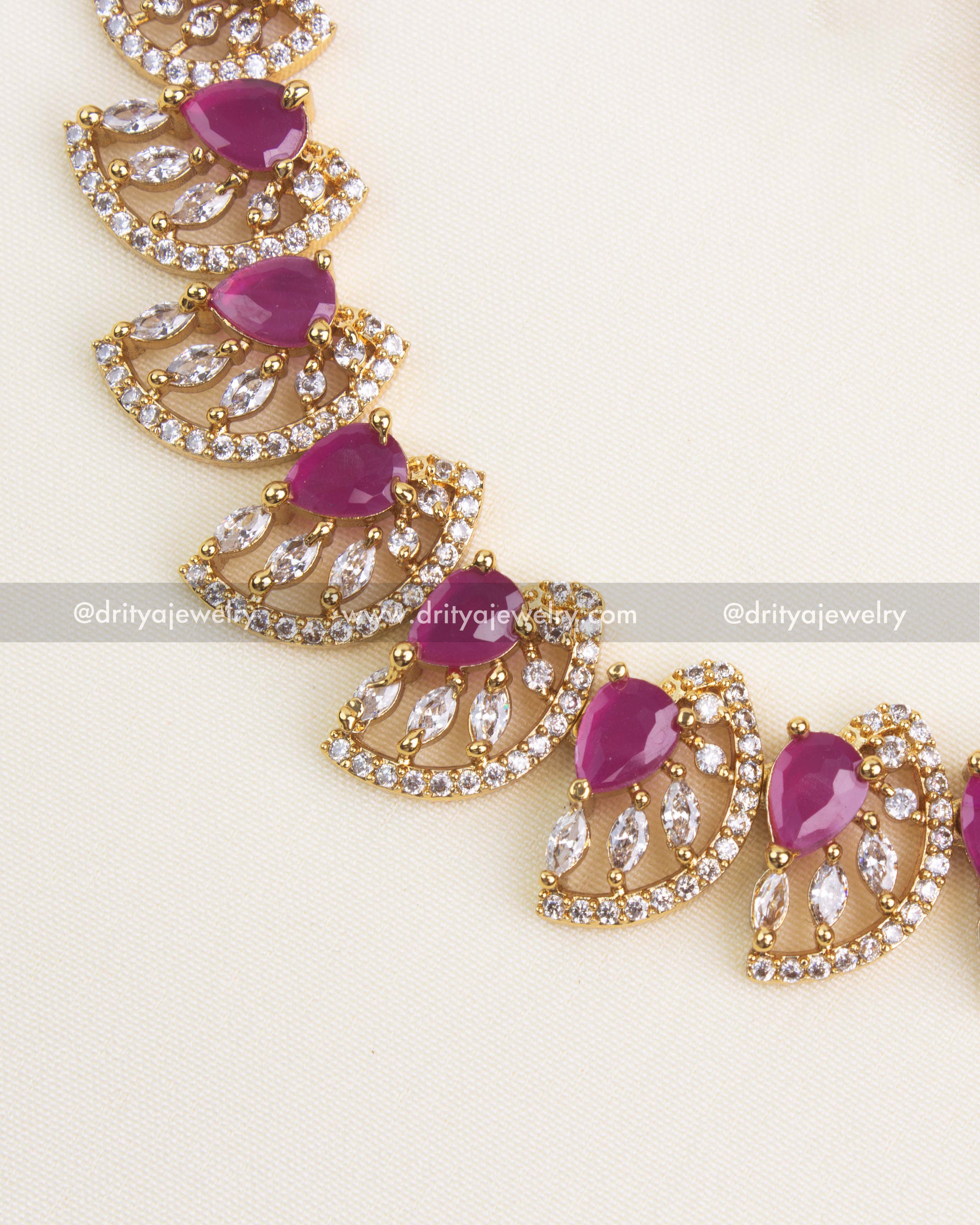 Close-up of ruby teardrop stones surrounded by CZ diamonds in a gold finish.