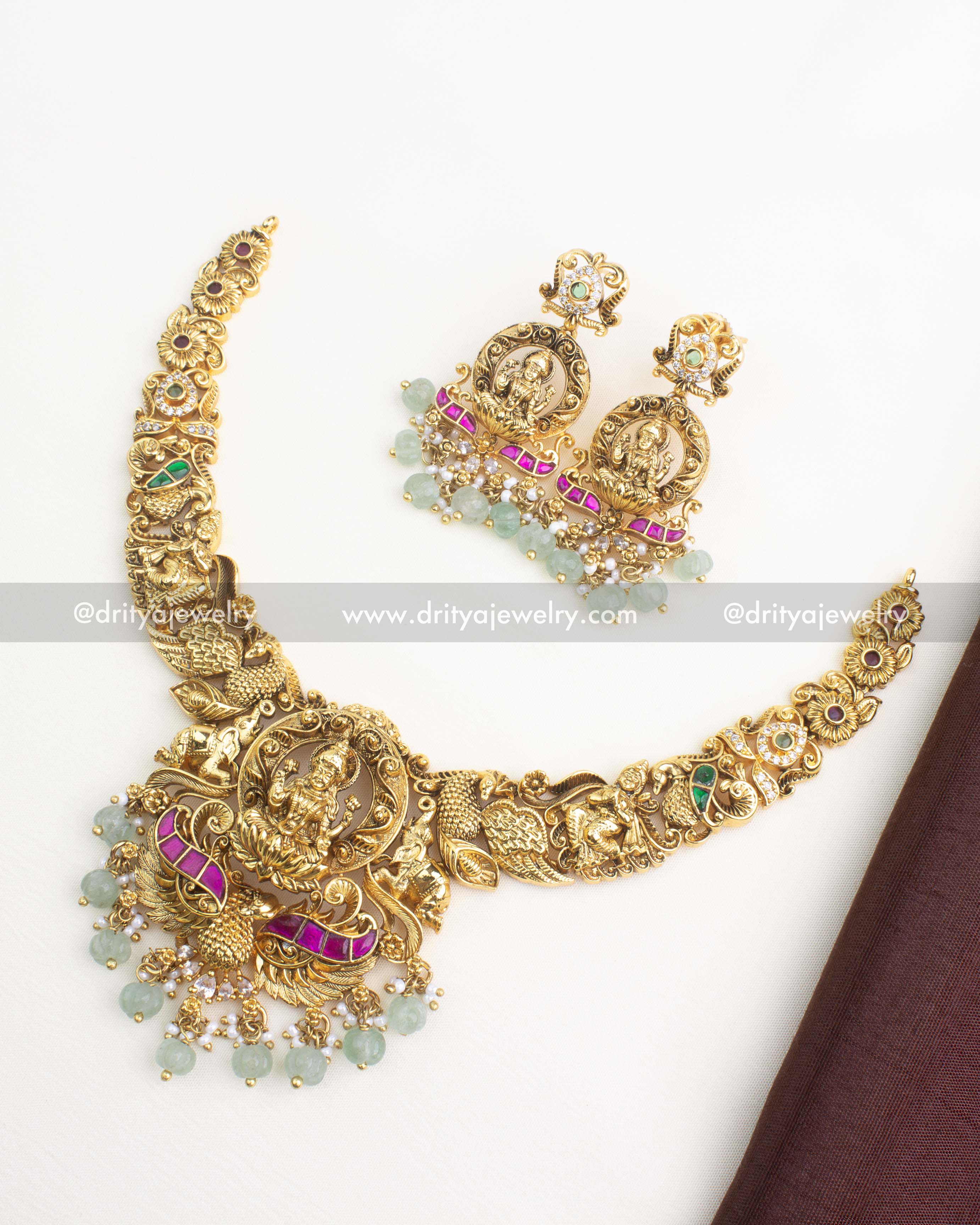 Antique gold temple necklace with Lakshmi pendant, nakshi detailing, kemp stones, and matching earrings