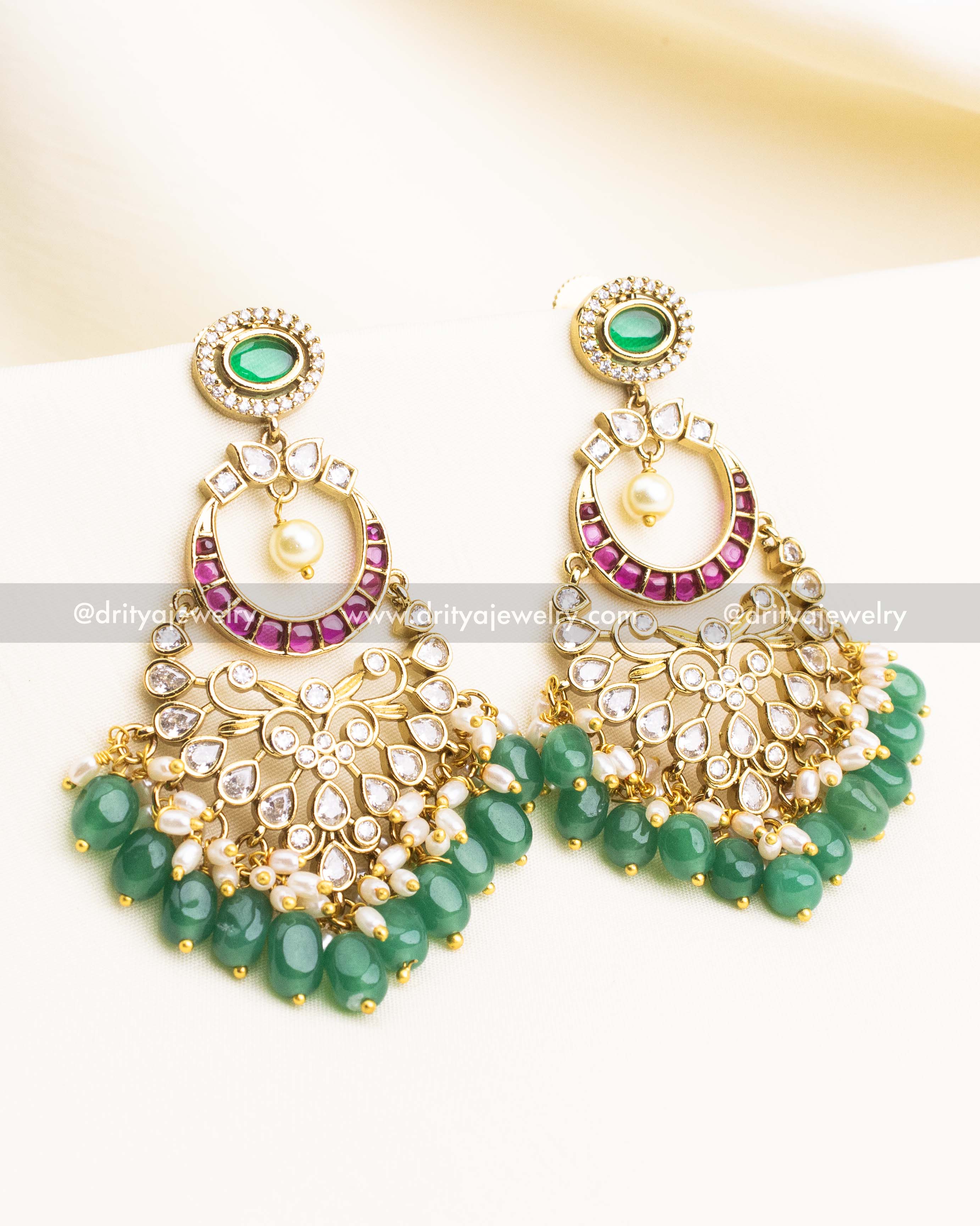 Gold-plated chandbali earrings with pink enamel, kundan stones, and green bead drops.