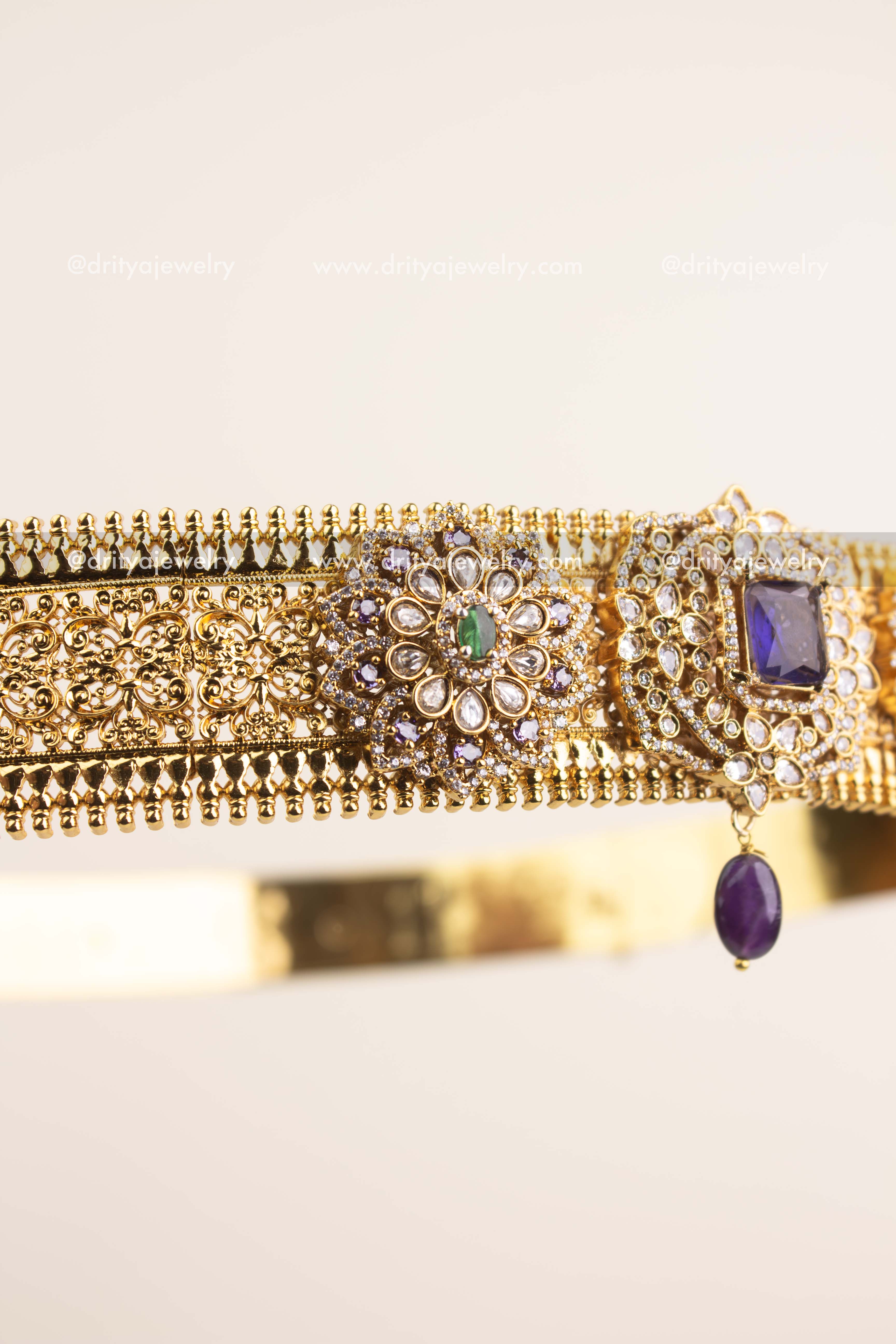 Handcrafted floral design featuring kundan stones, CZ detailing, and violet centerpiece.