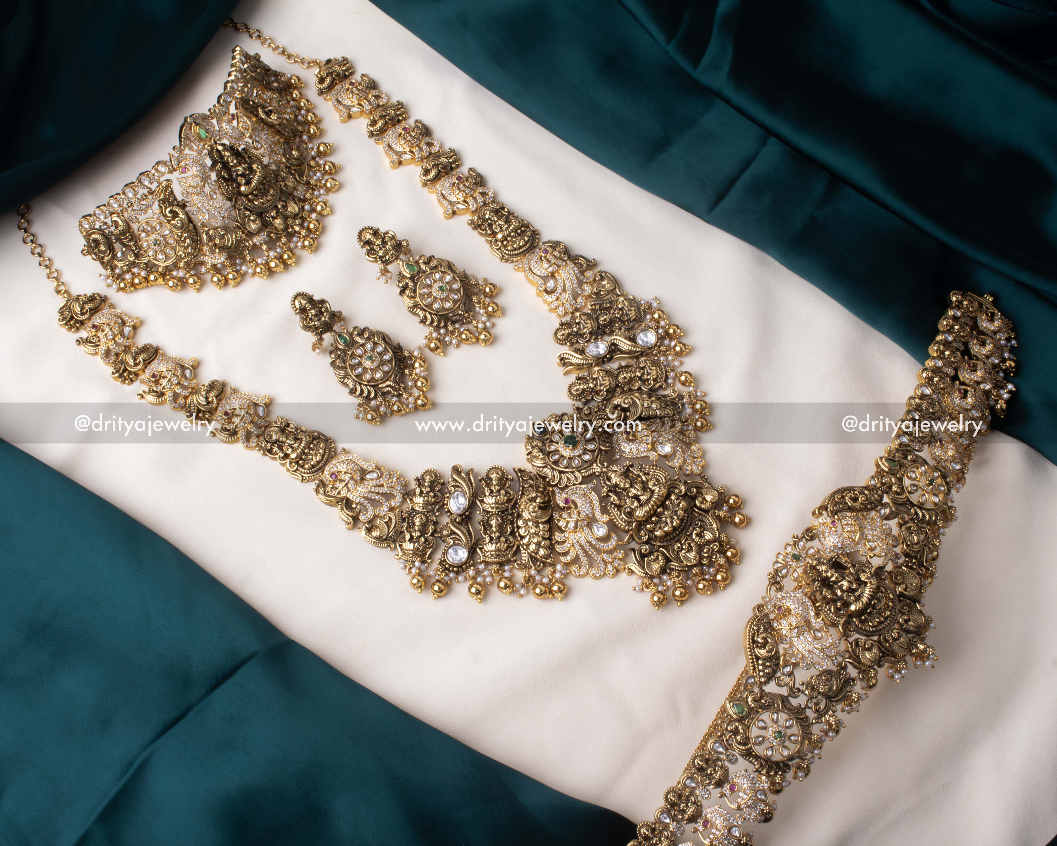 Complete view of premium Nakshi bridal set with choker, long necklace, earrings, and waist belt in antique gold finish.