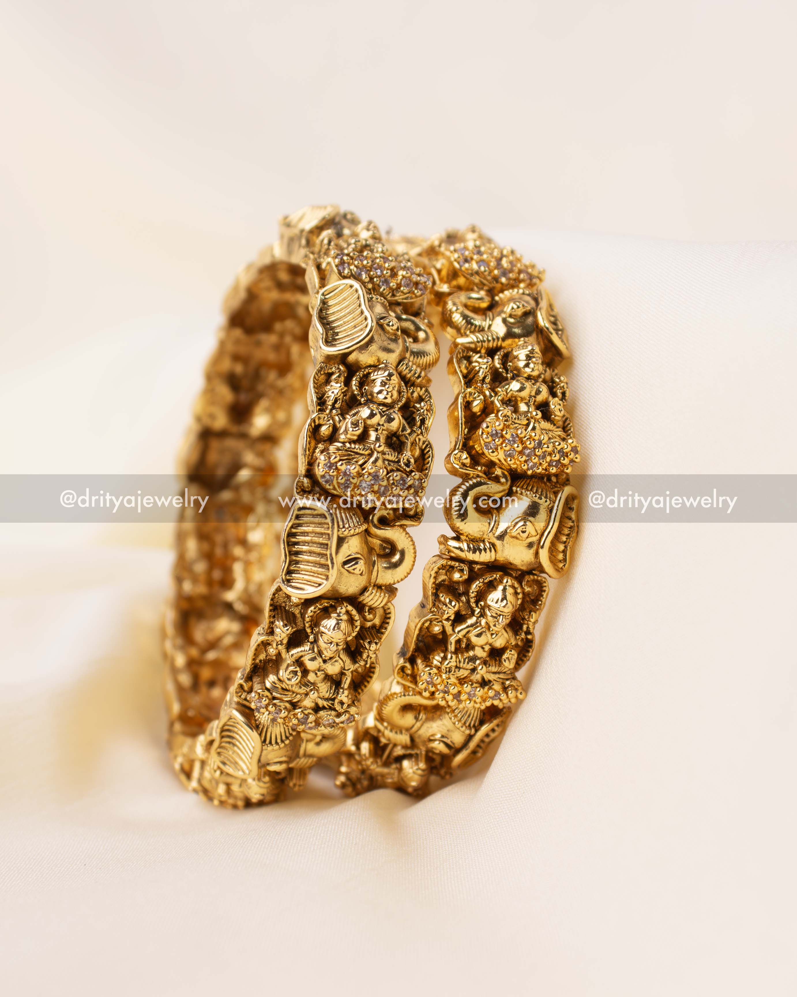 Set of antique gold bangles with intricate Nakshi carving of Lakshmi and elephants.