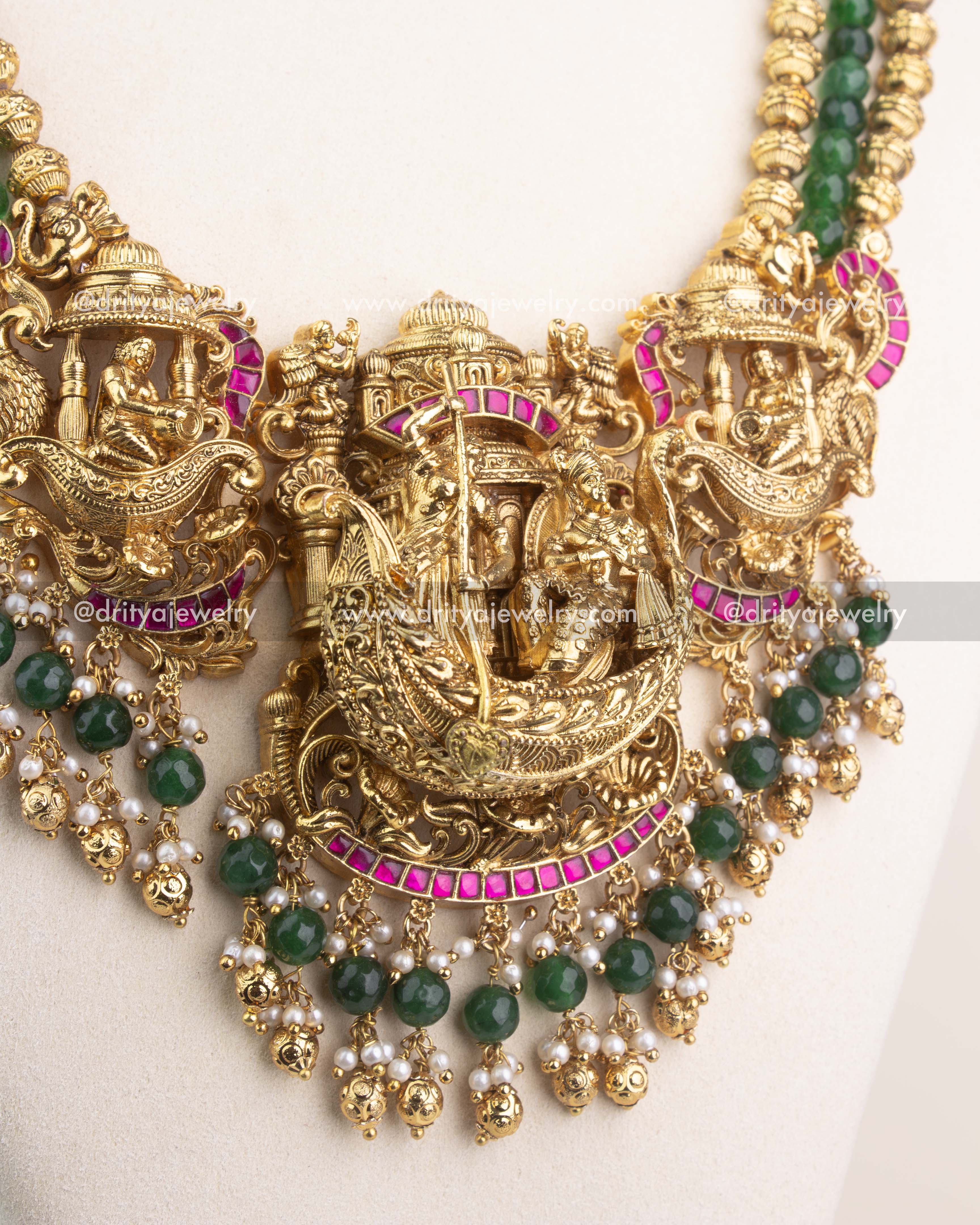 3D Nakshi pendant with Lord Krishna design, ruby Kemp detailing, and pearl-green bead accents.