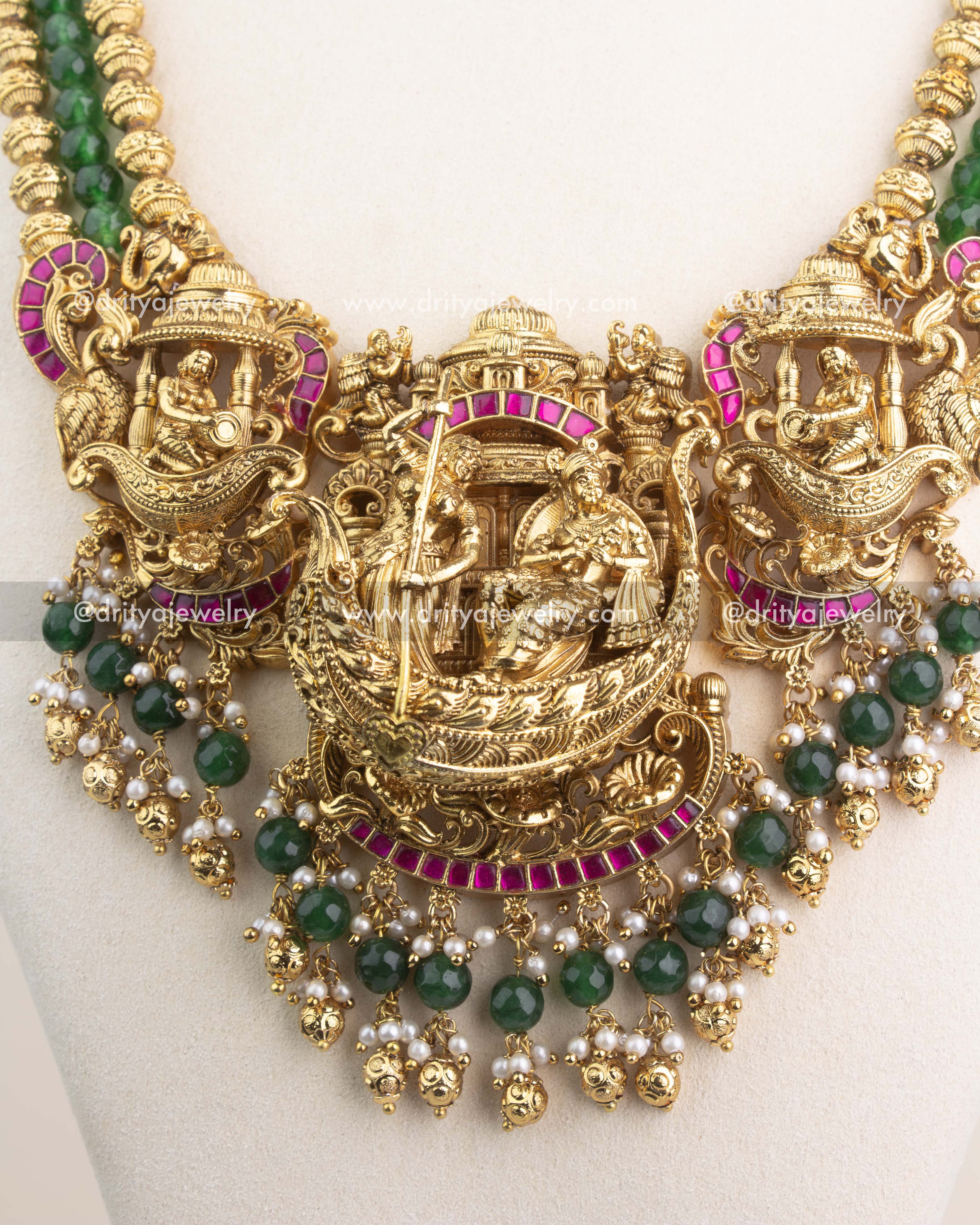 3D Nakshi pendant with Lord Krishna design, ruby Kemp detailing, and pearl-green bead accents.