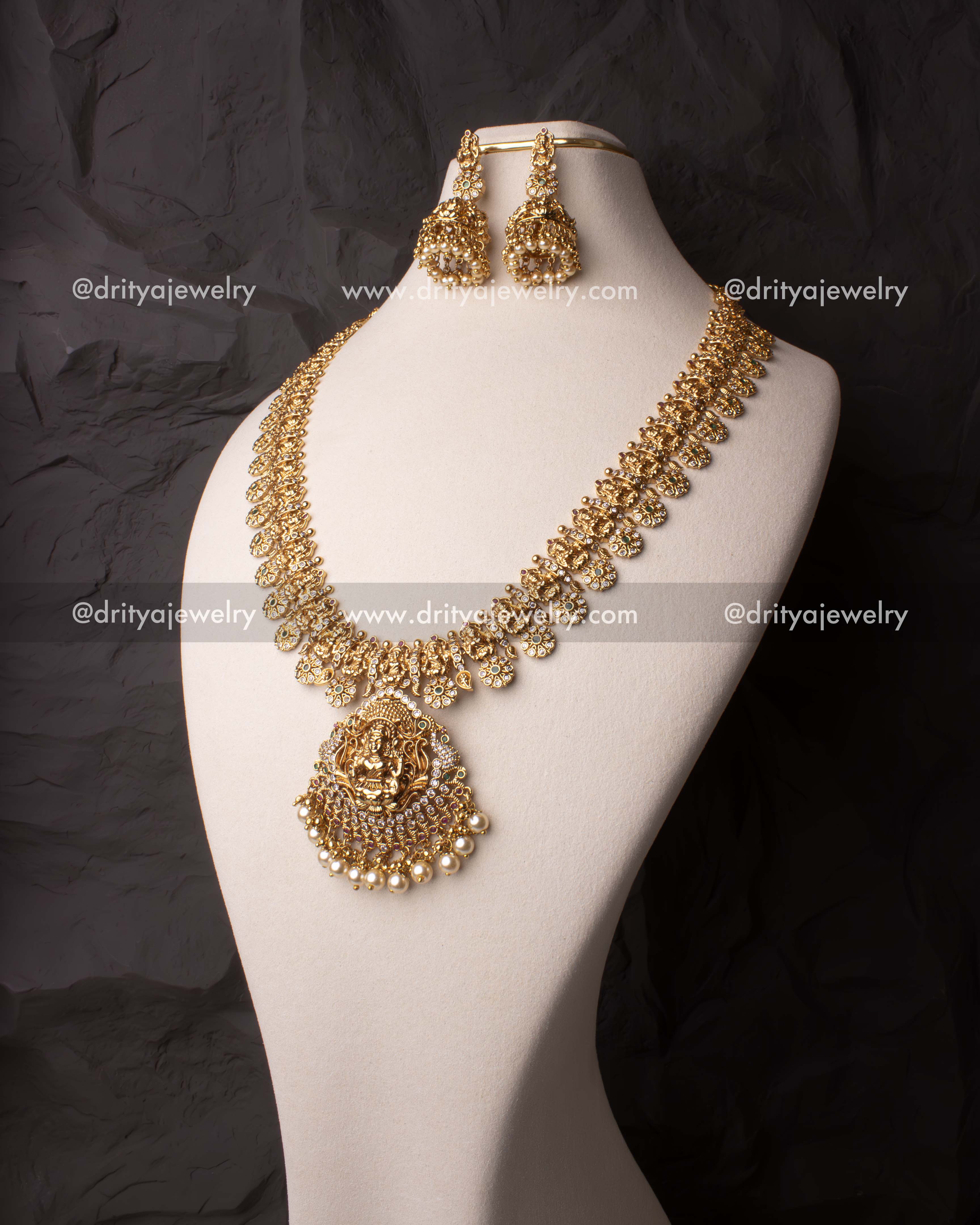 Exquisite Nakshi haram set featuring a Lakshmi pendant, Polki stones, and pearl embellishments, paired with temple-style Jhumka earrings.