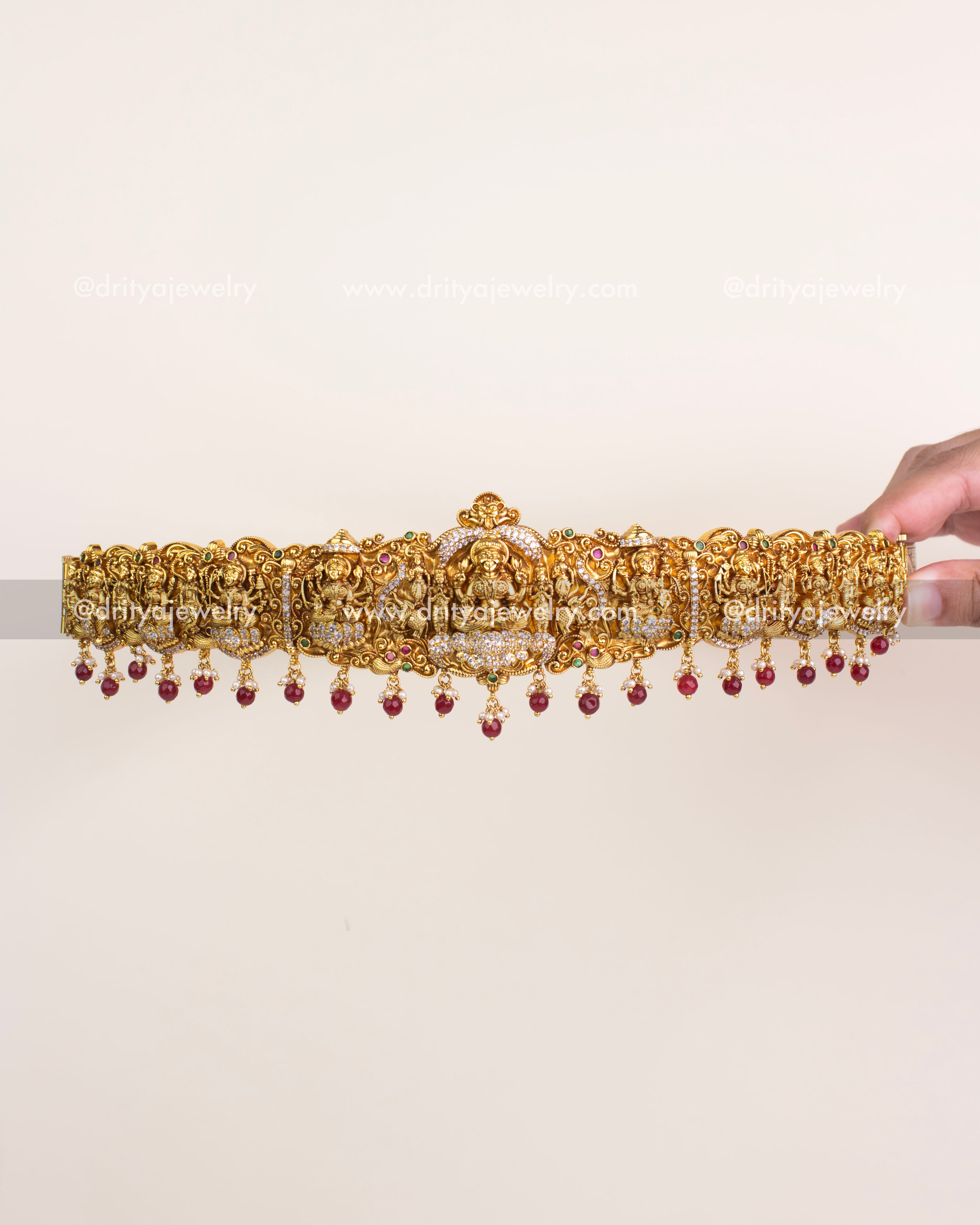 Antique gold temple vadanam with goddess motif and ruby bead hangings.